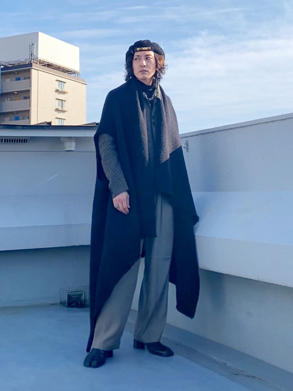 ブラック系のニット/セーター、ブラウン系のテーラードジャケット、ベージュ系のその他パンツを着用したメンズの冬コーディネートの2枚目の写真