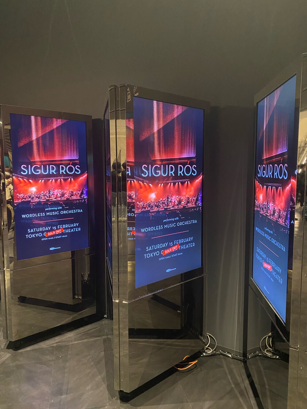 ブラック系のピーコート、レッド系のニット/セーター、ブルー系のデニムパンツを着用したメンズの冬コーディネートの5枚目の写真