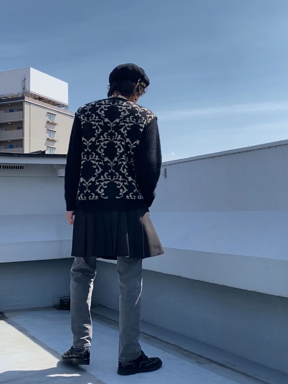 ブラック系のニット/セーター、ブラック系のスカート、グレー系のデニムパンツを着用したメンズの春コーディネートの4枚目の写真