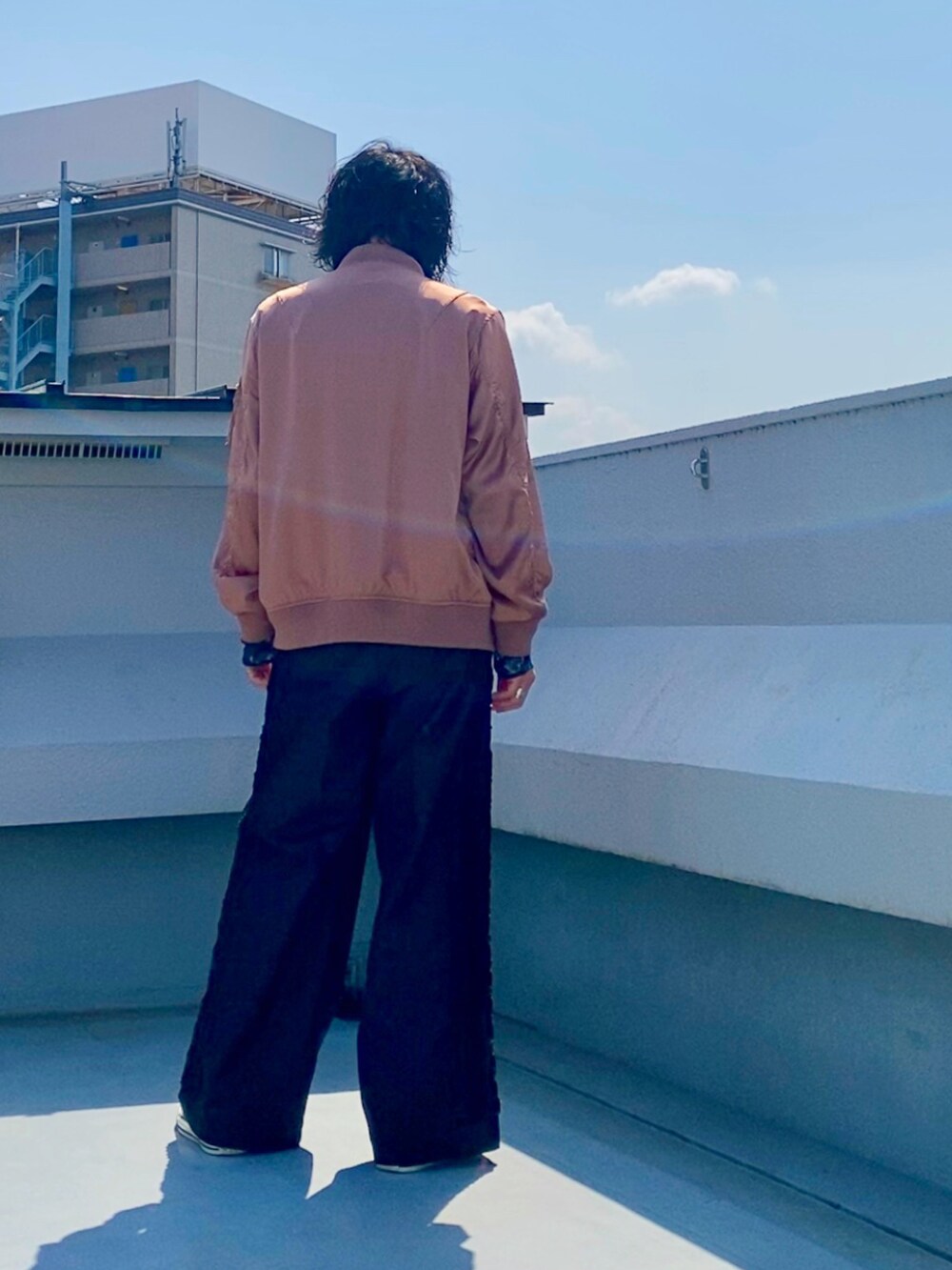 ピンク系のMA-1、ブラック系のTシャツ/カットソー、ブラック系のパンツを着用したメンズの春コーディネートの5枚目の写真