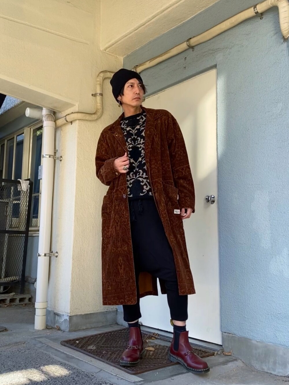 ブラック系のニット/セーター、ブラウン系のその他アウター、ブラック系のその他パンツを着用したメンズの冬コーディネートの4枚目の写真