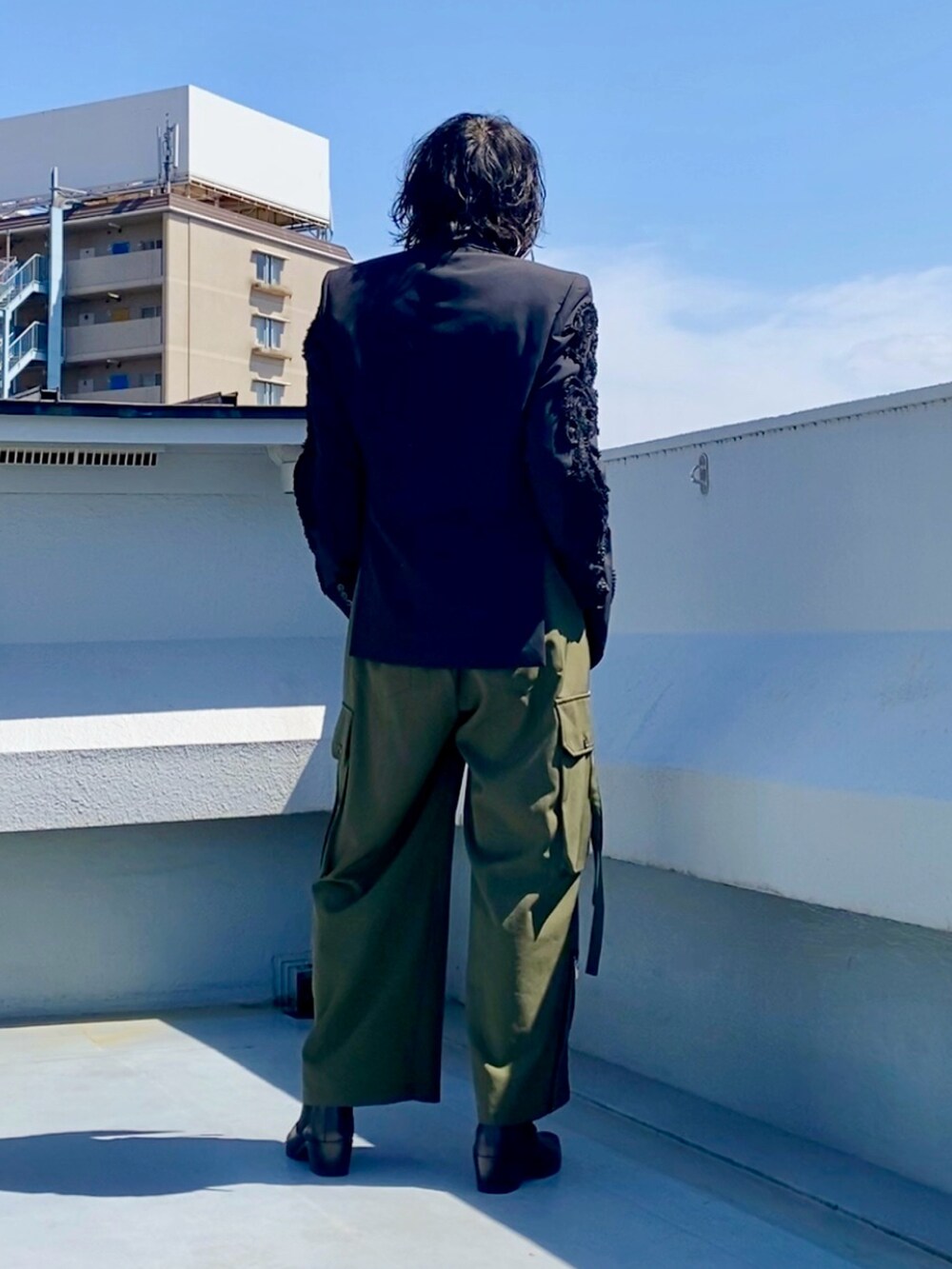 ブラック系のテーラードジャケット、ブラック系のTシャツ/カットソー、グリーン系のカーゴパンツを着用したメンズの春コーディネートの3枚目の写真