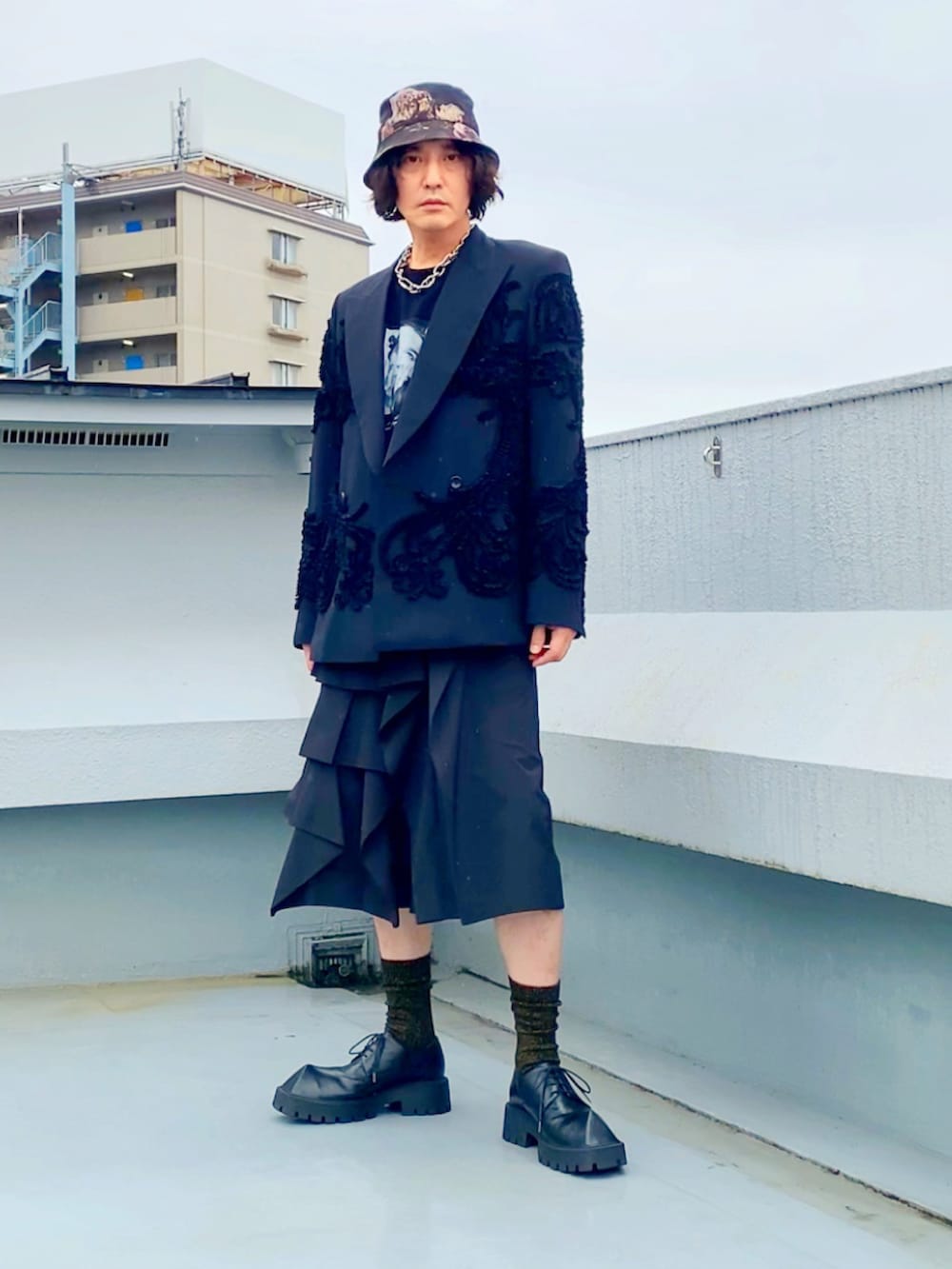 ブラック系のTシャツ/カットソー、ブラック系のテーラードジャケット、ブラック系のパンツを着用したメンズの秋コーディネートの5枚目の写真