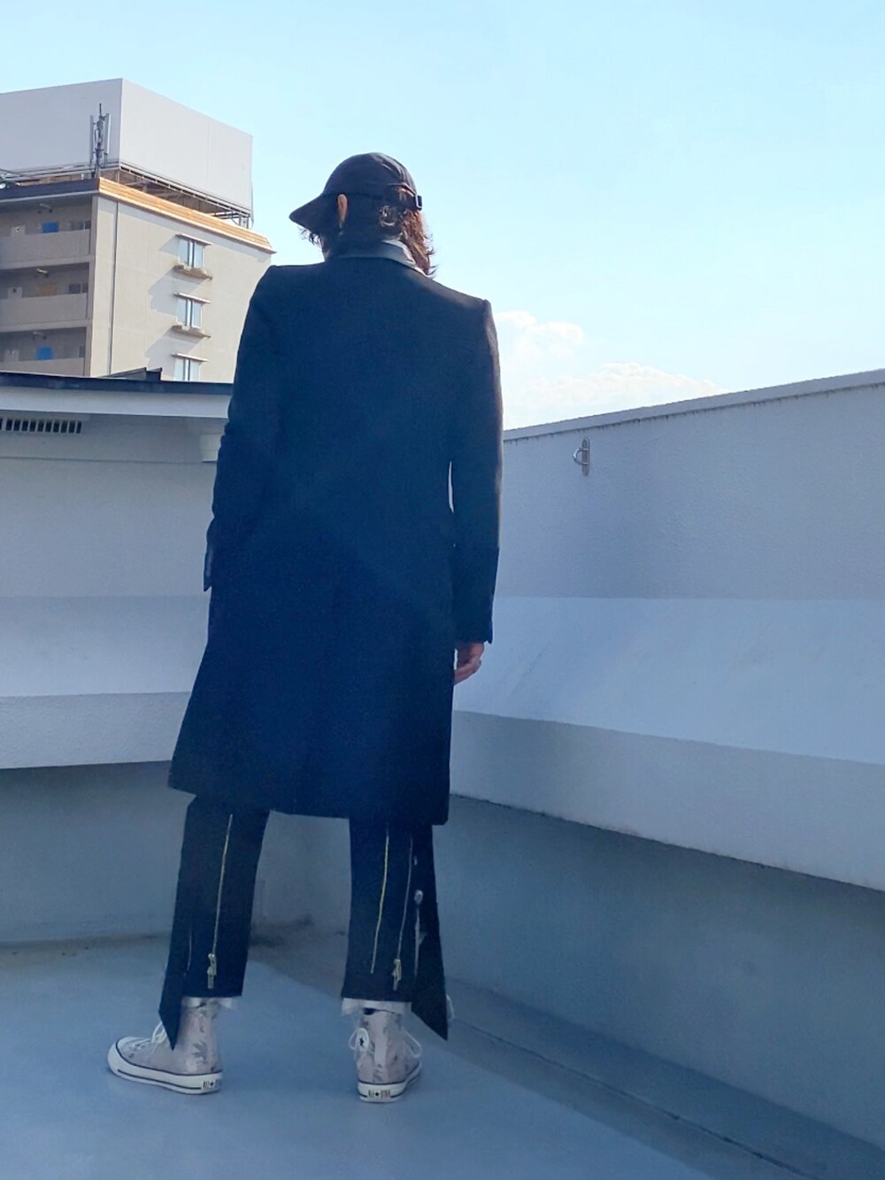 ブラック系のチェスターコート、ホワイト系のシャツ/ブラウス、ブラック系のニット/セーターを着用したメンズの冬コーディネートの4枚目の写真