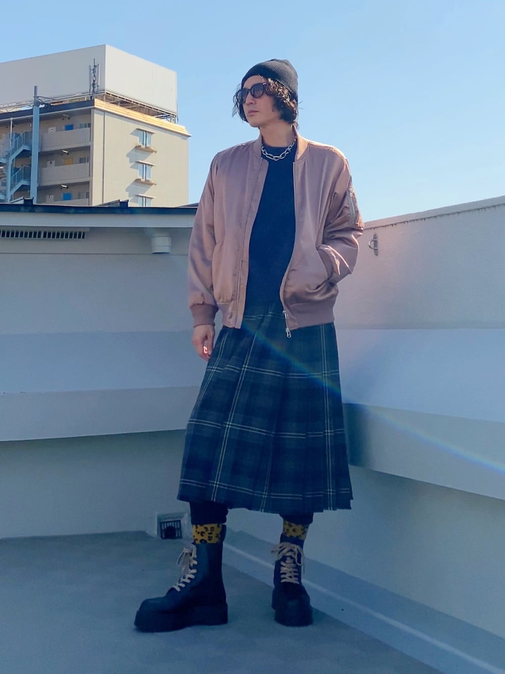 ブラック系のブーツ、パープル系のニット/セーター、ピンク系のMA-1を着用したメンズの冬コーディネートの5枚目の写真