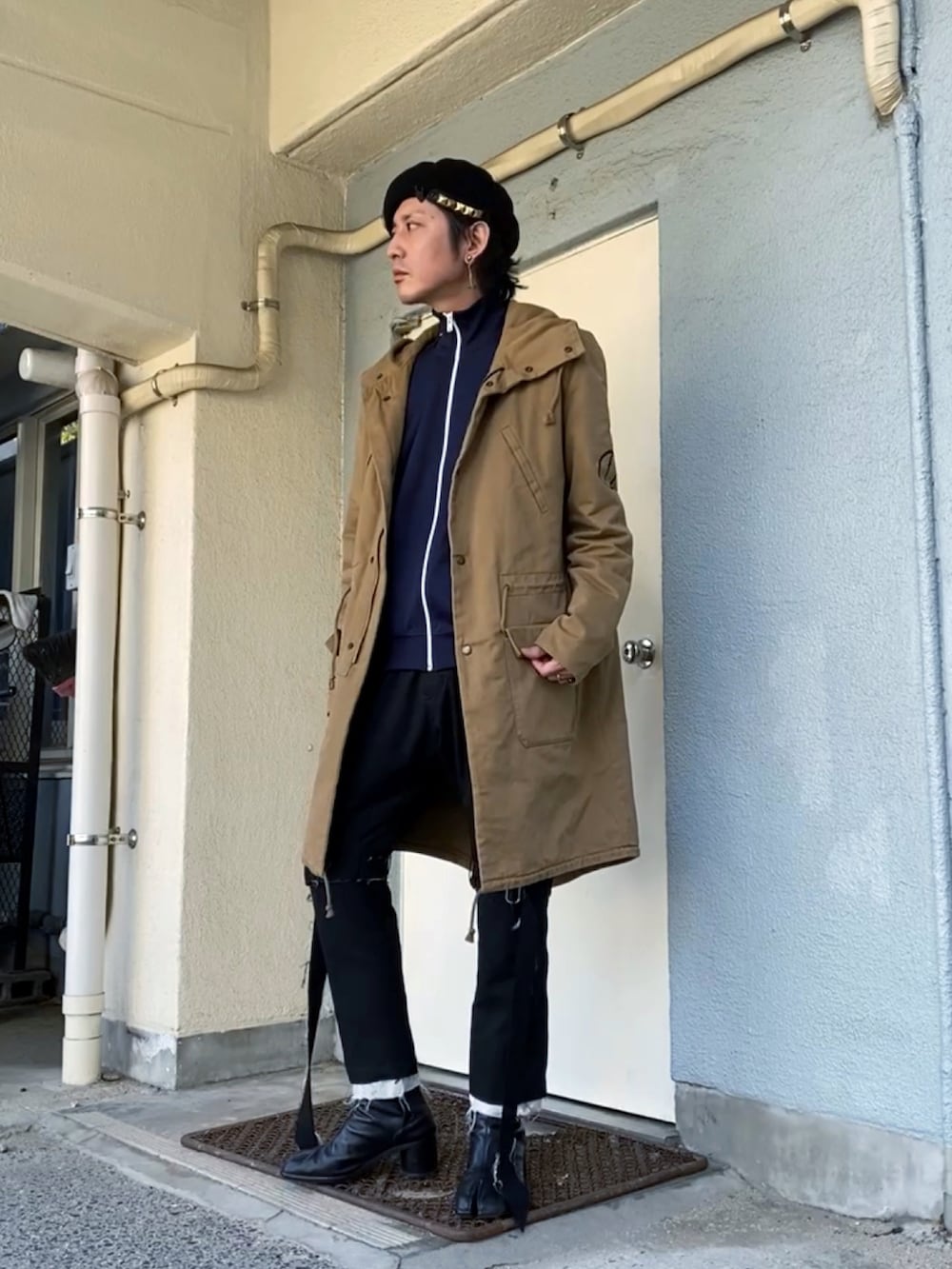 ベージュ系のモッズコート、ブルー系のジャージ、ブラック系のその他パンツを着用したメンズの冬コーディネートの2枚目の写真