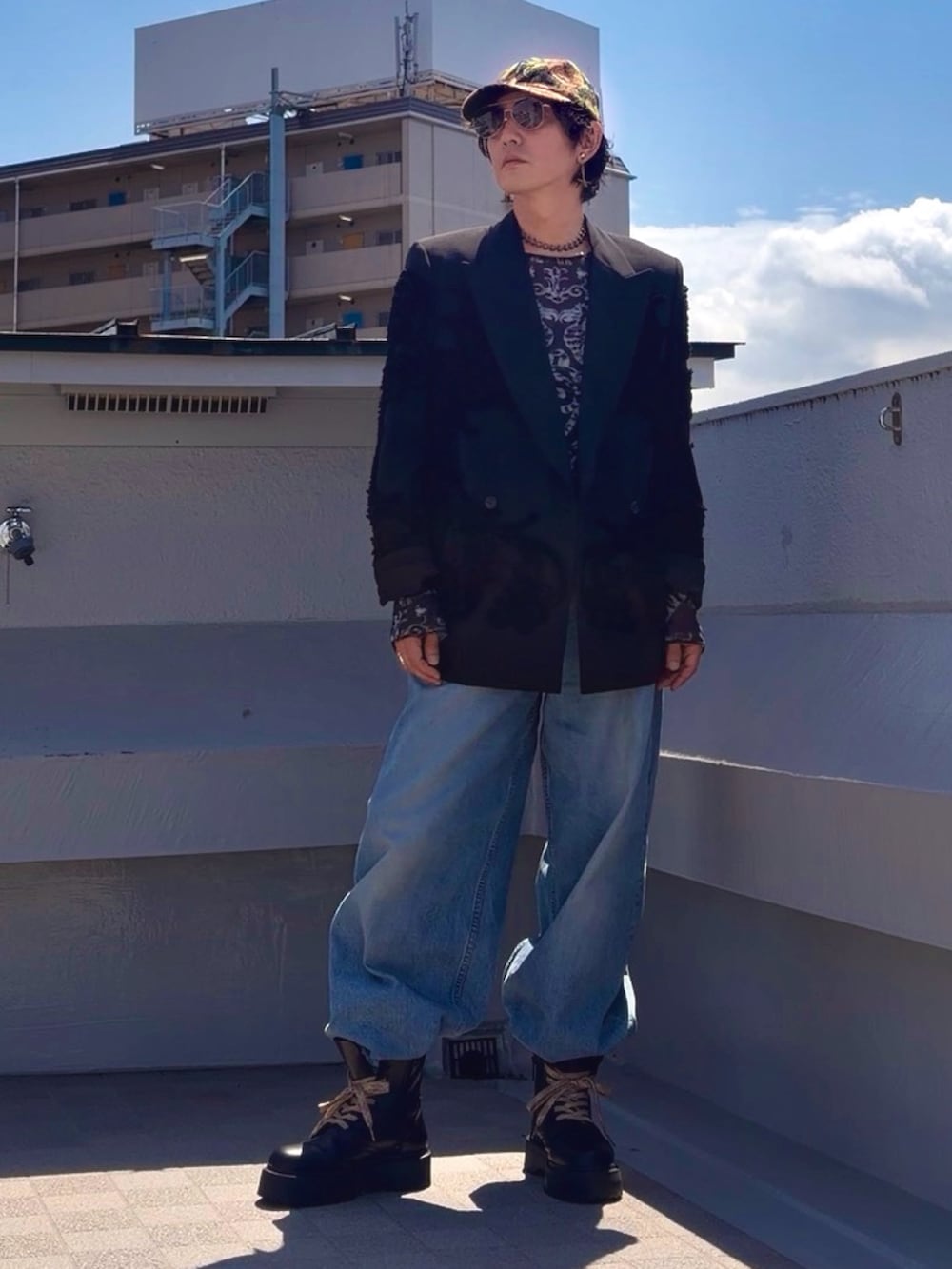 ブラック系のブーツ、ブルー系のデニムパンツ、ブラック系のTシャツ/カットソーを着用したメンズの春コーディネートの2枚目の写真