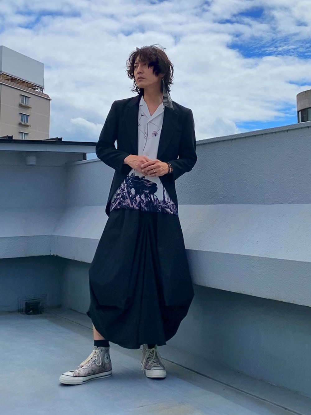 ブラック系のテーラードジャケット、ホワイト系のシャツ/ブラウス、ブラック系のスカートを着用したメンズの秋コーディネートの3枚目の写真