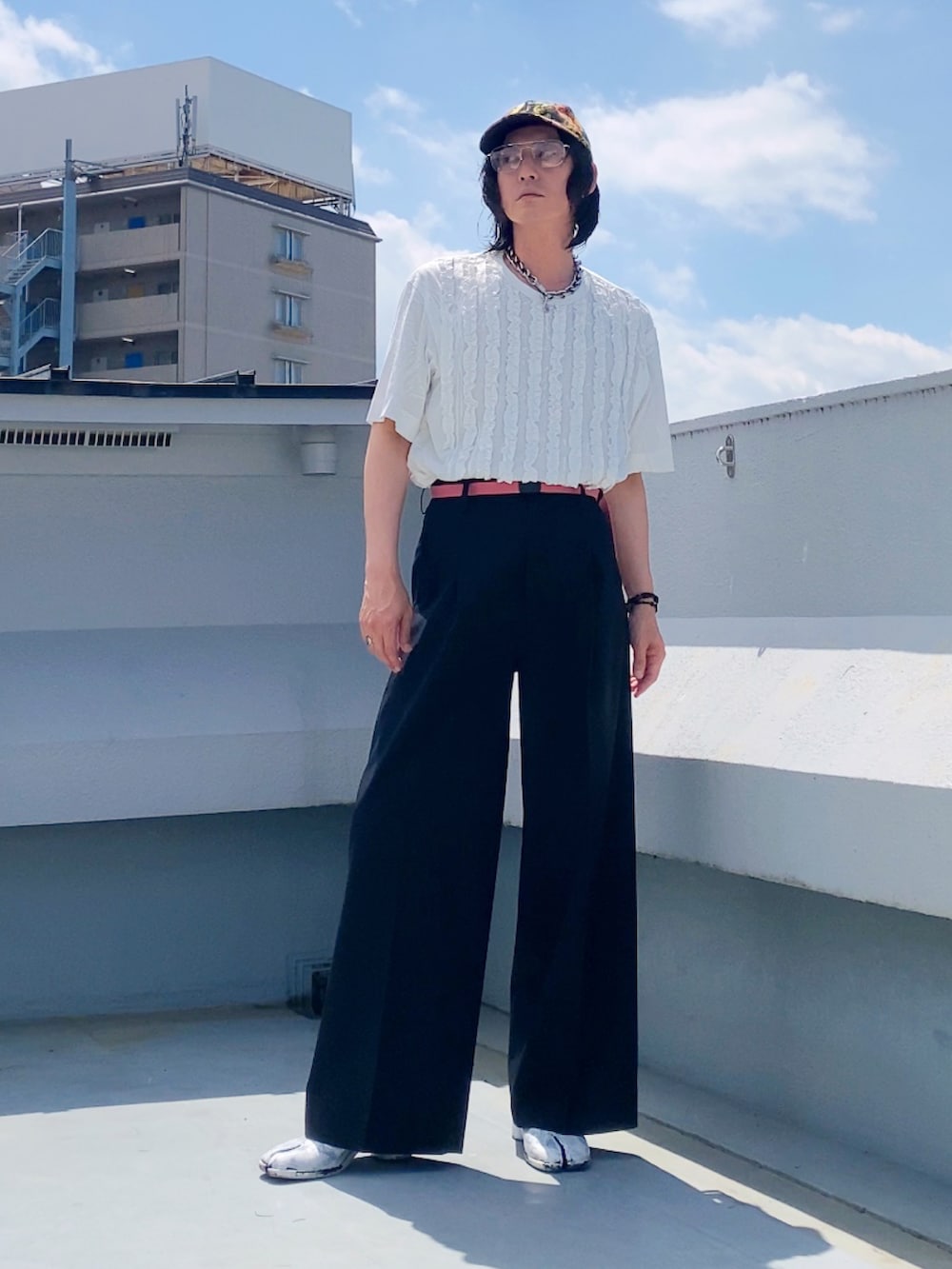 ホワイト系のTシャツ/カットソー、ブラック系のスラックス、ホワイト系のブーツを着用したメンズの夏コーディネートの2枚目の写真