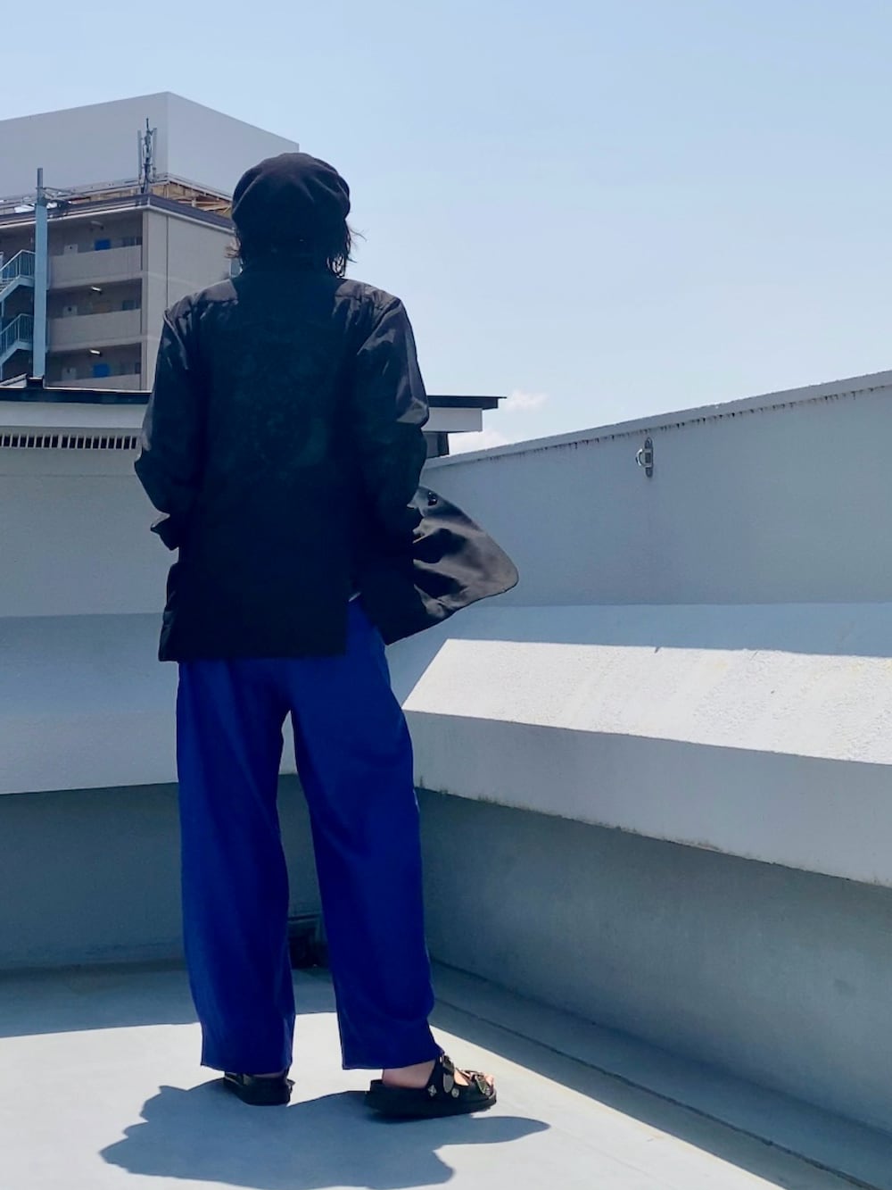 ブラック系のシャツ/ブラウス、ブラック系のTシャツ/カットソー、ブルー系のスラックスを着用したメンズの夏コーディネートの4枚目の写真