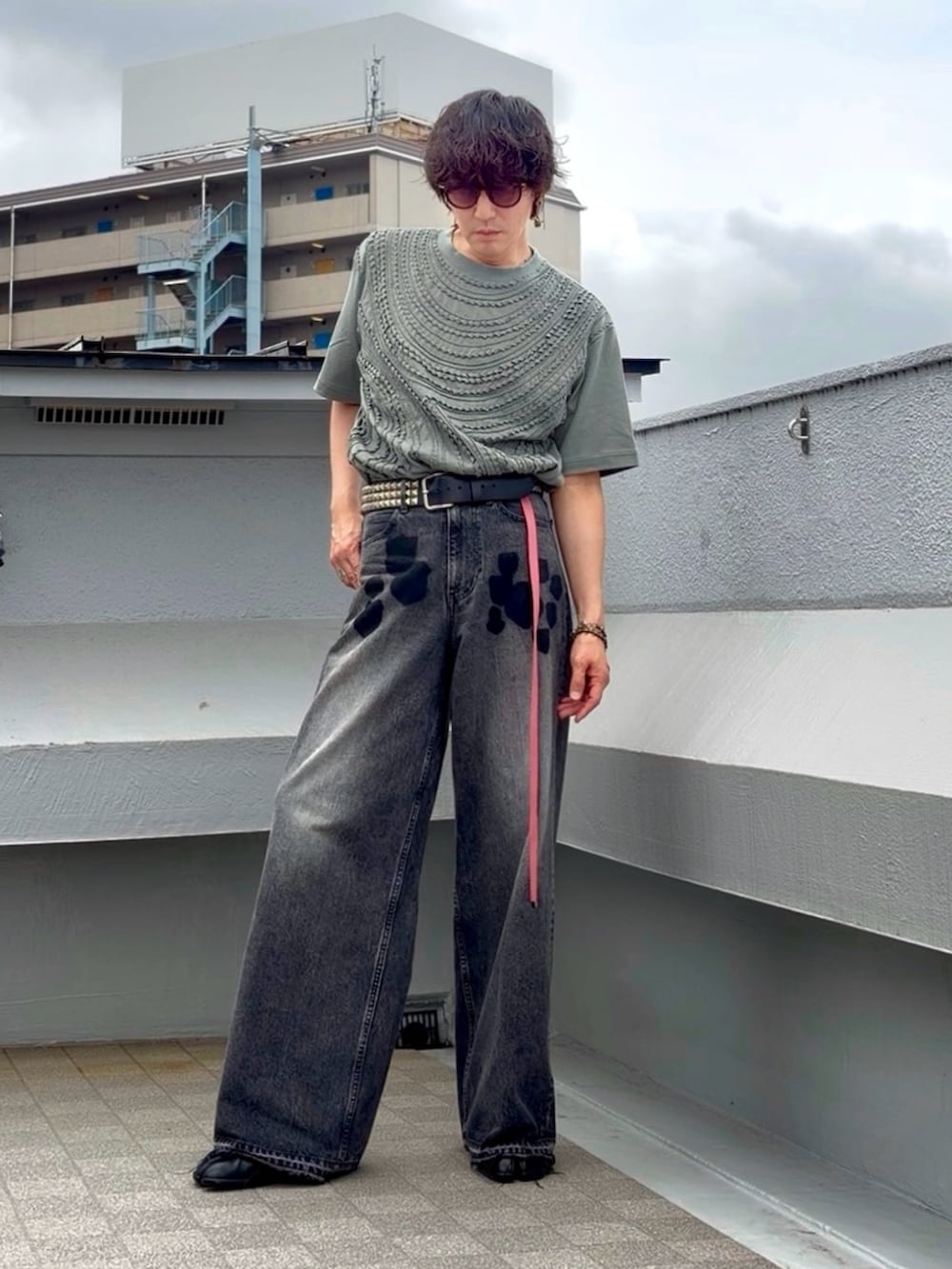ブラック系のデニムパンツ、ブラック系のブーツ、グリーン系のTシャツ/カットソーを着用したメンズの夏コーディネートの3枚目の写真
