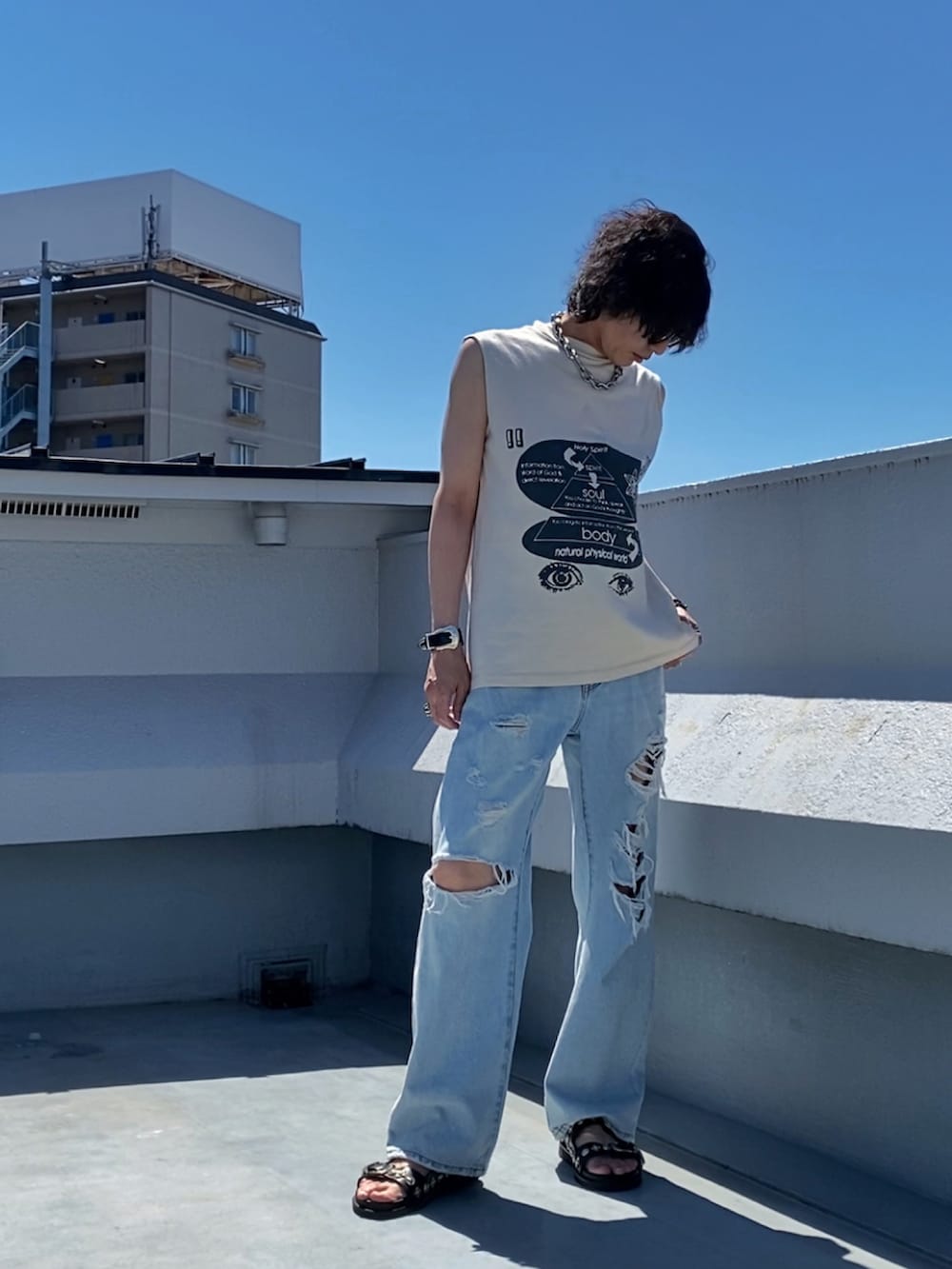 ベージュ系のTシャツ/カットソー、ブルー系のデニムパンツ、ブラック系のサンダルを着用したメンズの夏コーディネートの2枚目の写真