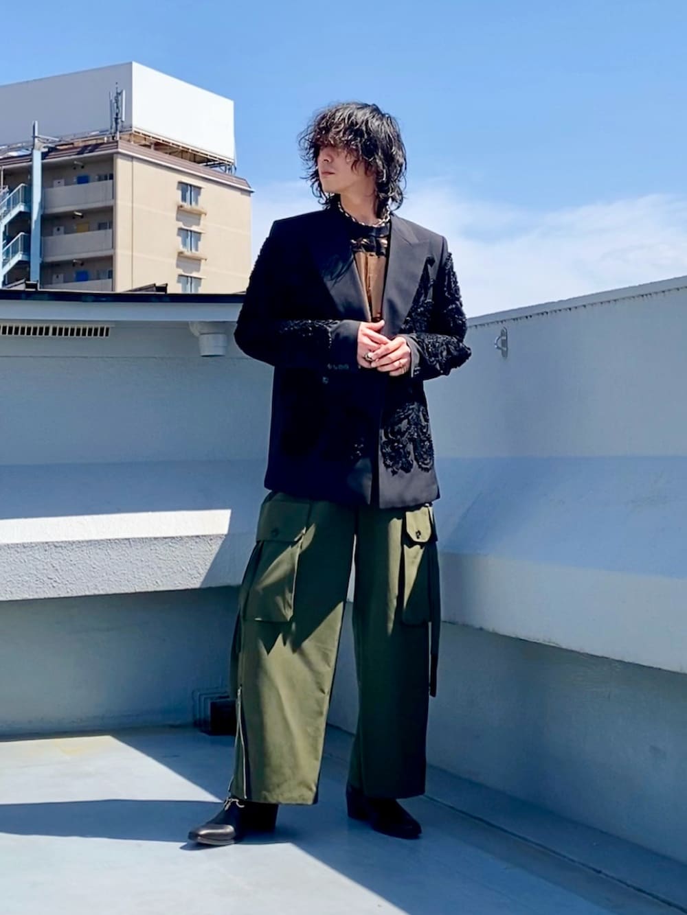 ブラック系のテーラードジャケット、ブラック系のTシャツ/カットソー、グリーン系のカーゴパンツを着用したメンズの春コーディネートの4枚目の写真