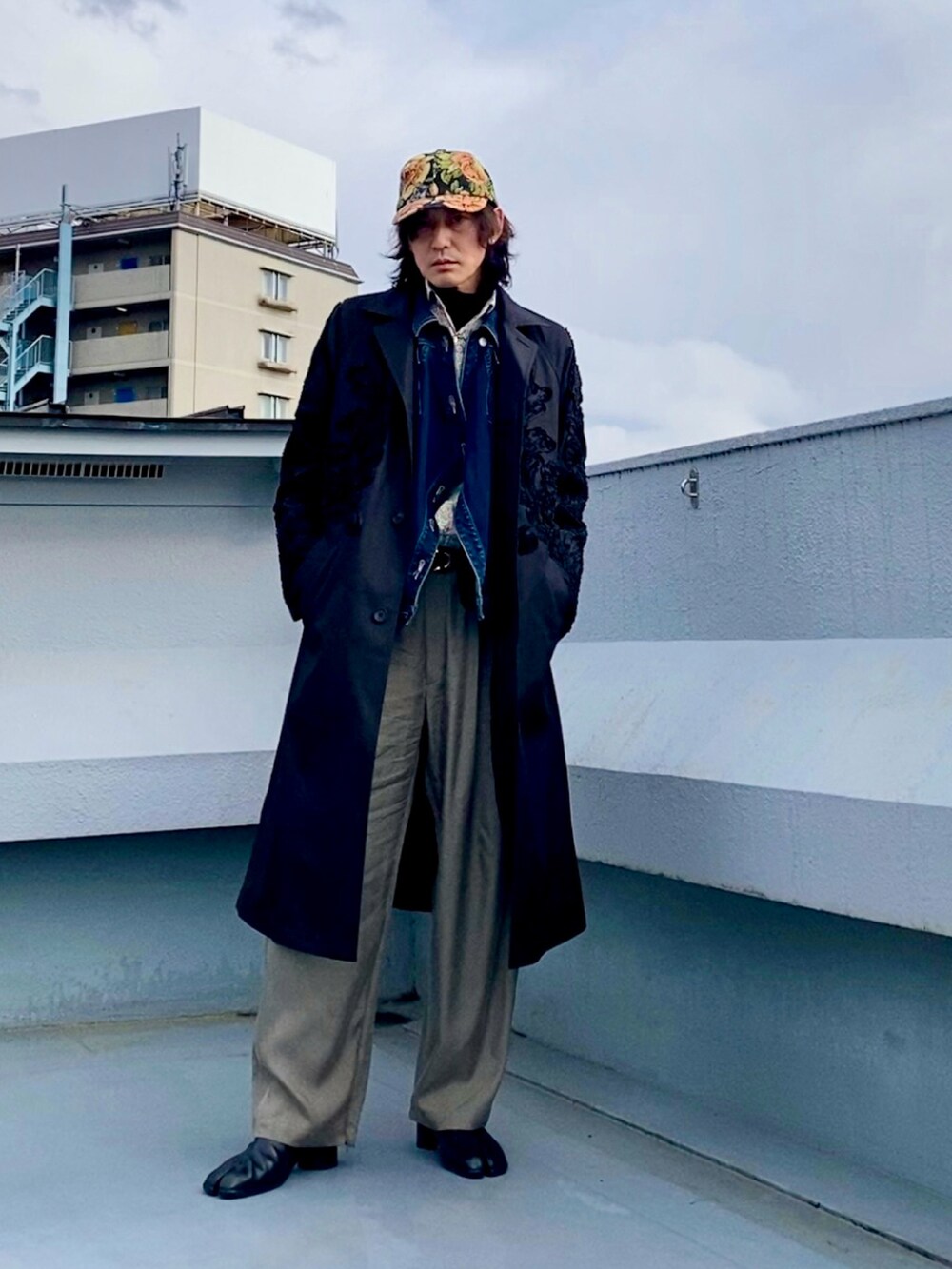 ブラック系のブーツ、ホワイト系のシャツ/ブラウス、ブラック系のステンカラーコートを着用したメンズの春コーディネートの5枚目の写真