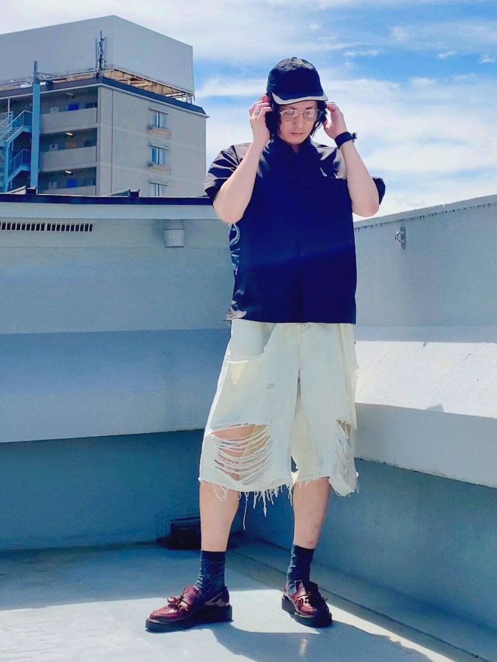 ホワイト系のデニムパンツ、ブラック系のシャツ/ブラウス、レッド系のローファーを着用したメンズの夏コーディネートの3枚目の写真