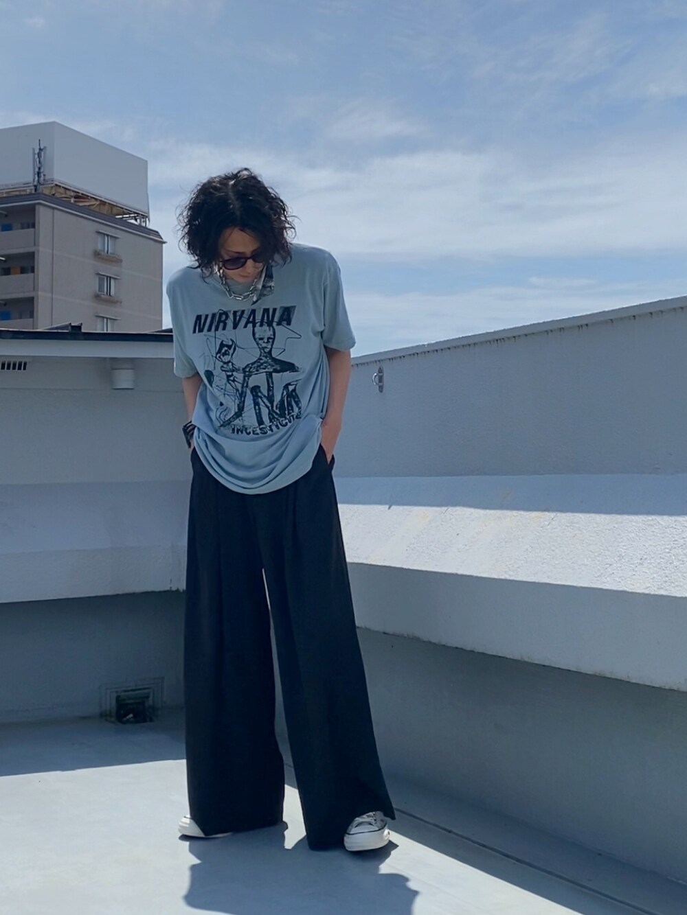 グリーン系のTシャツ/カットソー、ブラック系のスラックス、ベージュ系のスニーカーを着用したメンズの夏コーディネートの4枚目の写真