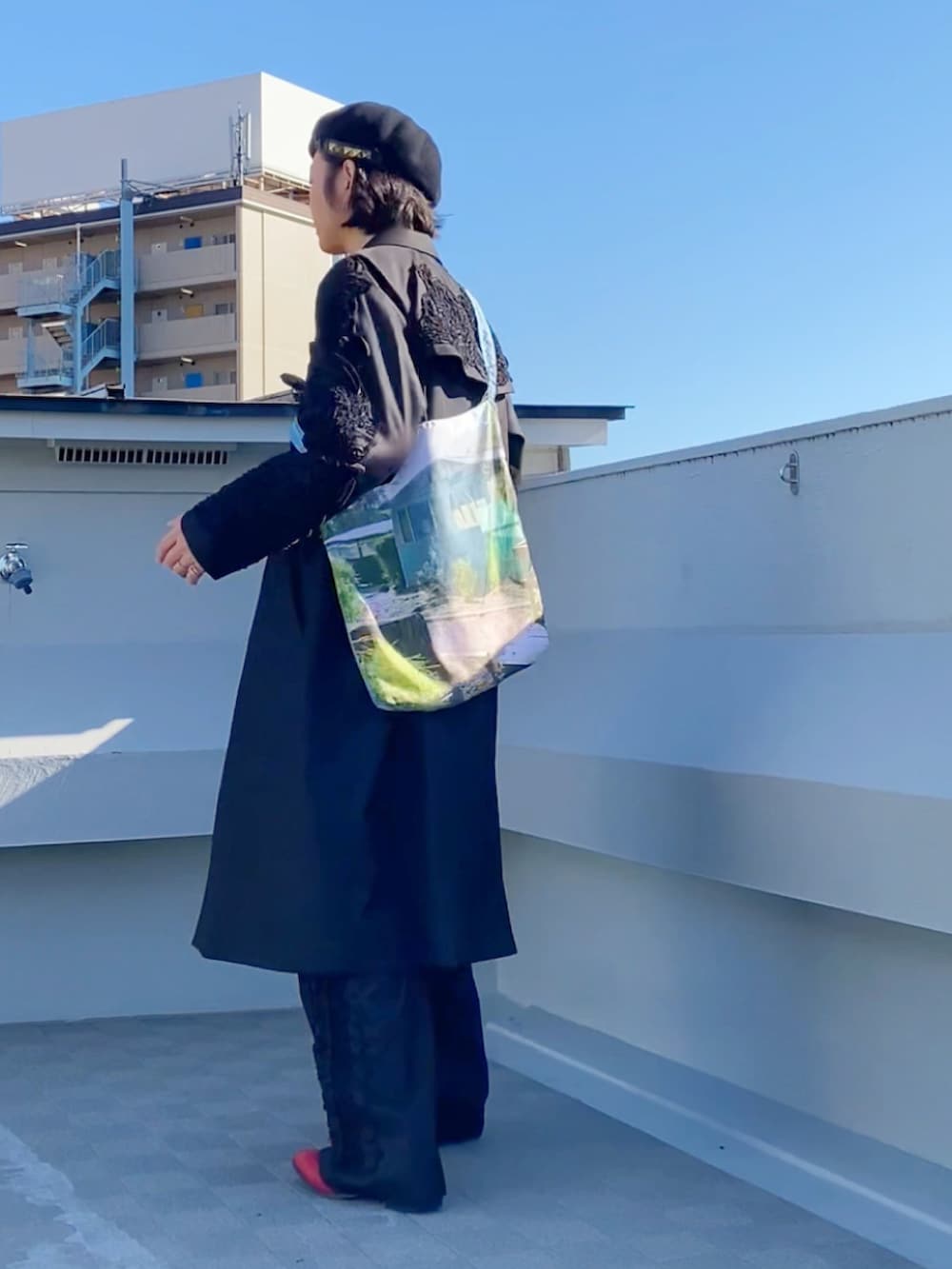 レッド系のニット/セーター、ブラック系のステンカラーコート、ブラック系のパンツを着用したメンズの冬コーディネートの3枚目の写真