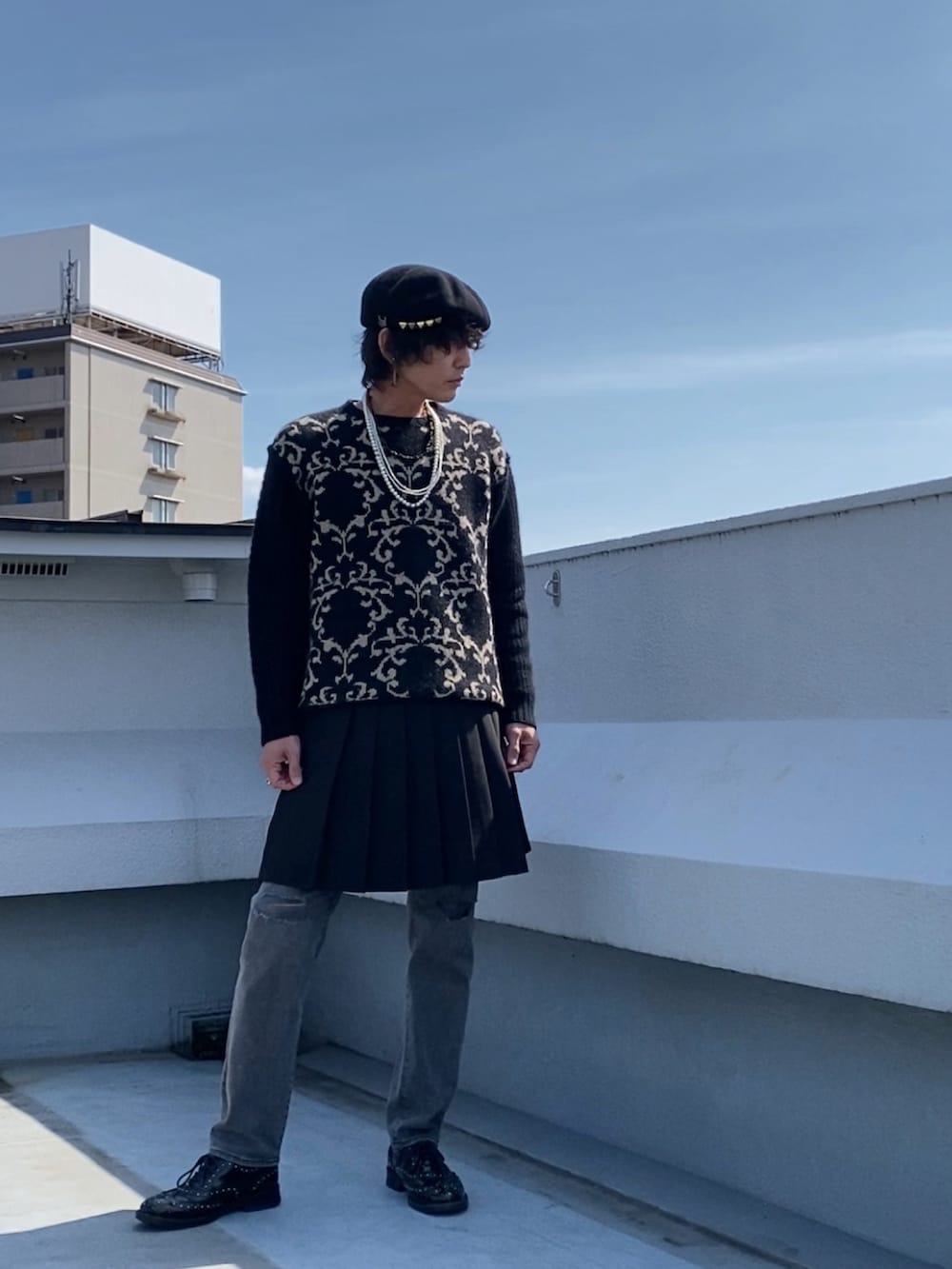 ブラック系のニット/セーター、ブラック系のスカート、グレー系のデニムパンツを着用したメンズの春コーディネートの3枚目の写真