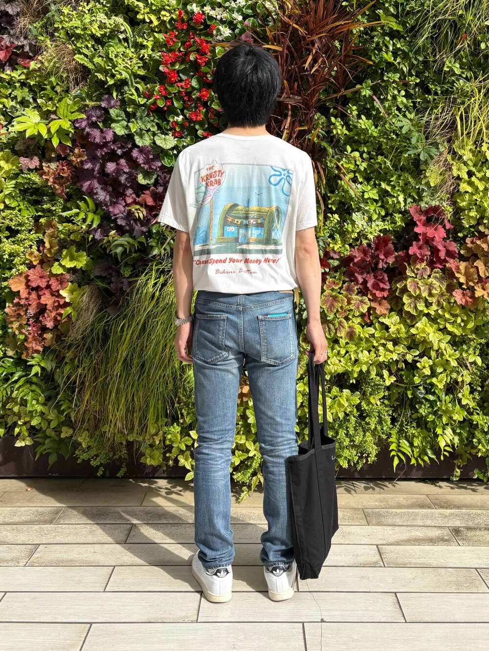 ホワイト系のTシャツ/カットソー、ブルー系のデニムパンツ、ホワイト系のスニーカーを着用したメンズの夏コーディネートの2枚目の写真