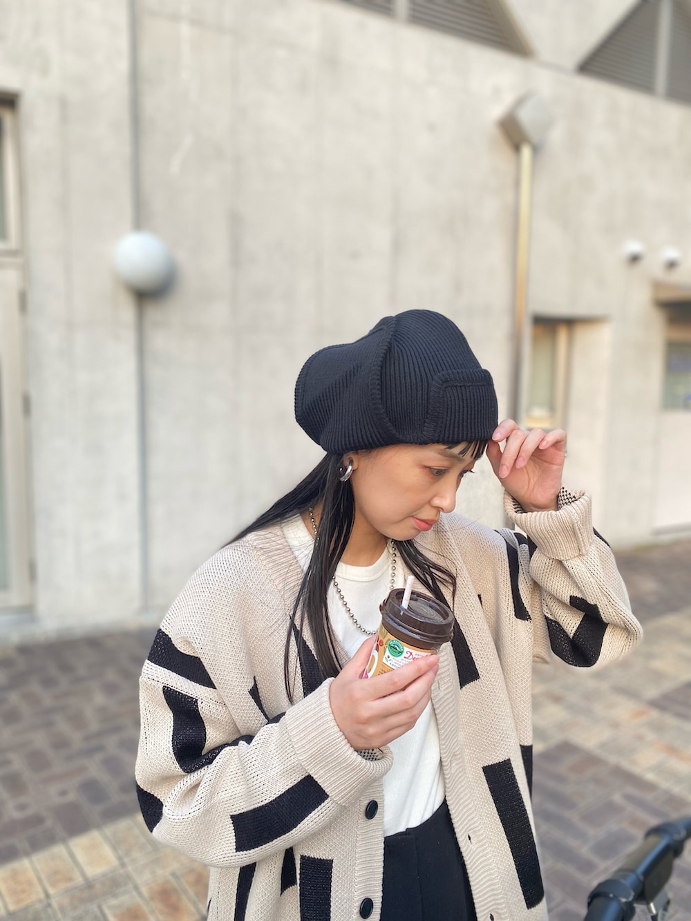 ベージュ系のカーディガン/ボレロ、ホワイト系のスニーカー、ホワイト系のTシャツ/カットソーを着用したレディースの秋コーディネートの3枚目の写真