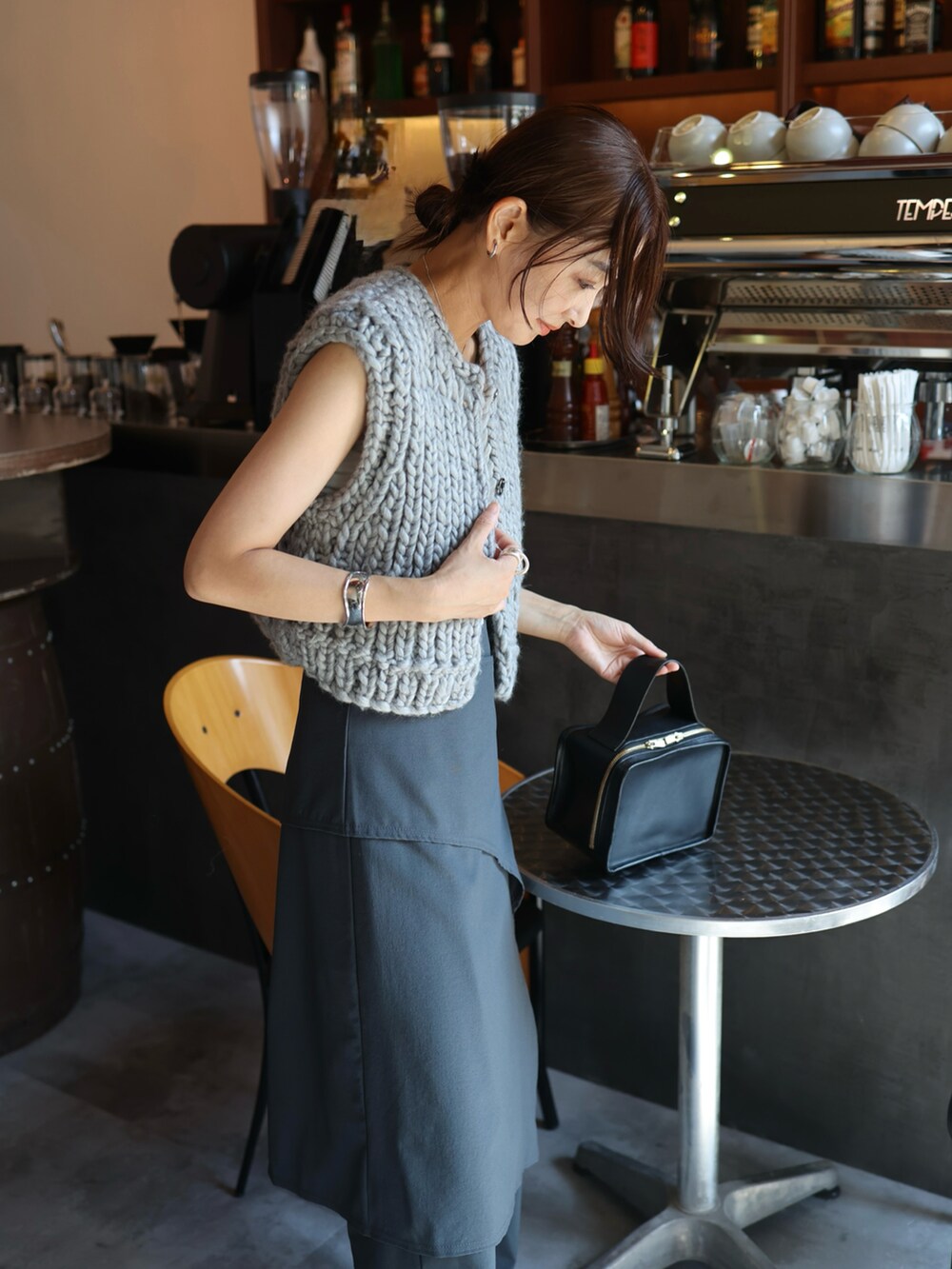 グレー系のスラックス、グレー系のスニーカー、ホワイト系のチューブトップを着用したレディースの秋コーディネートの3枚目の写真