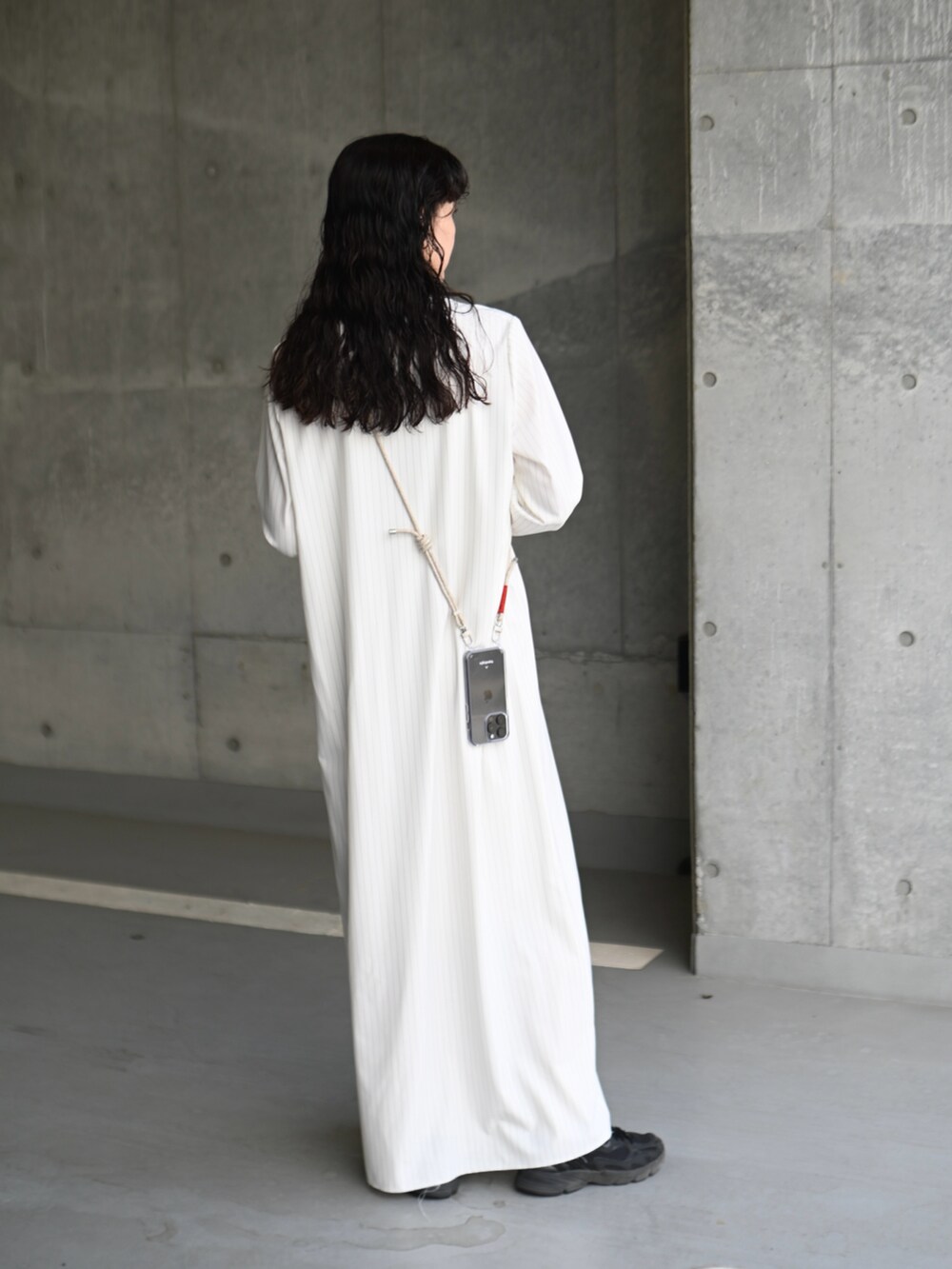 ホワイト系のワンピース、ブラック系のスニーカー、ブラック系のキャミソールを着用したレディースの春コーディネートの3枚目の写真