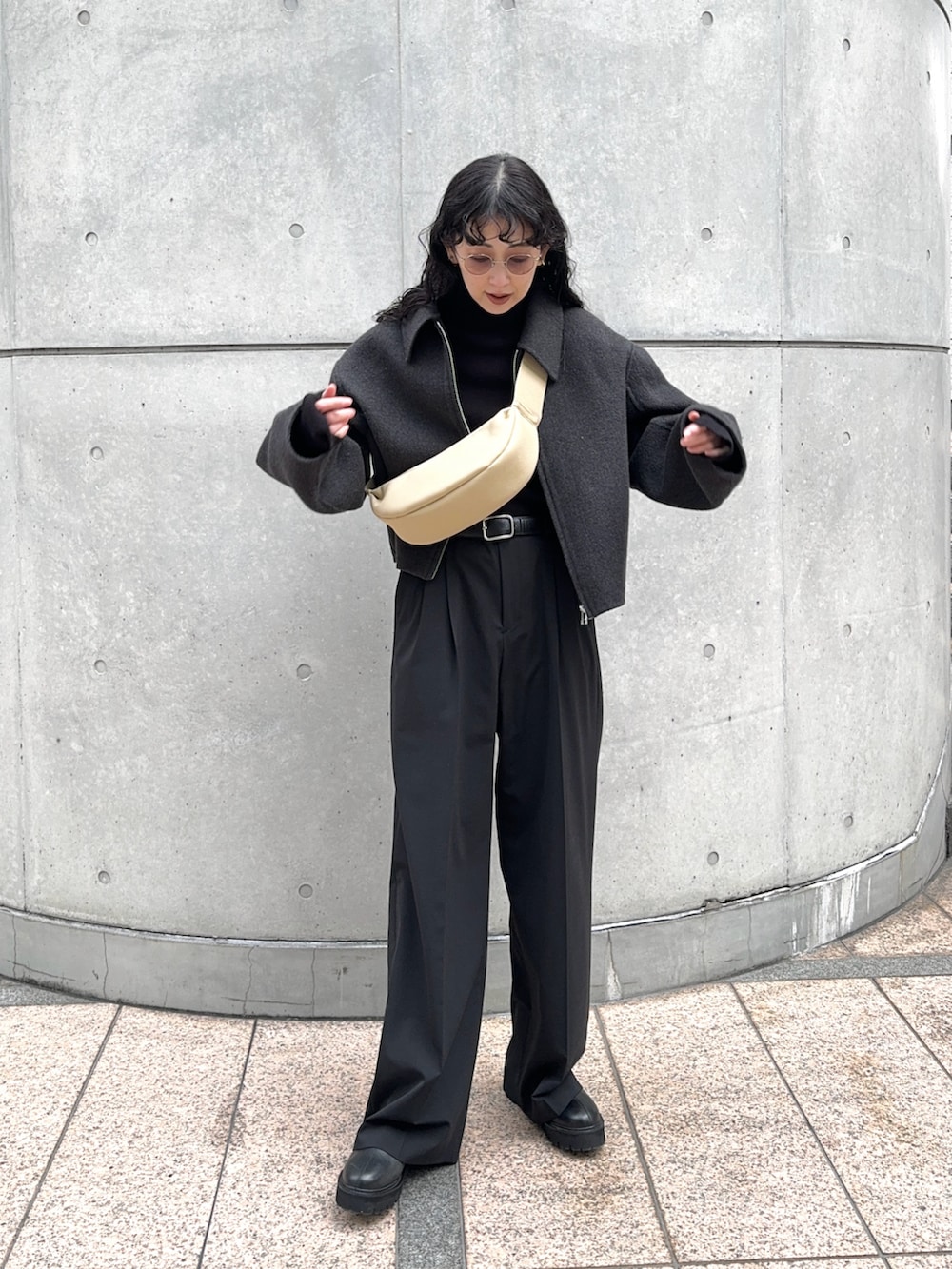 グレー系のブルゾン、ブラック系のスラックス、ブラック系のブーツを着用したレディースの冬コーディネートの3枚目の写真