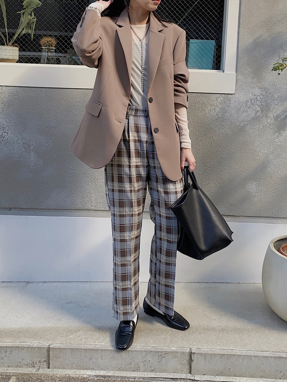 ブラウン系のテーラードジャケット、ブルー系のスラックス、ホワイト系のTシャツ/カットソーを着用したレディースの冬コーディネートの2枚目の写真