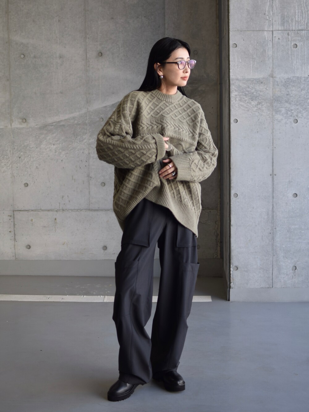 グリーン系のニット/セーター、グリーン系のカーゴパンツ、ブラック系のブーツを着用したレディースの秋コーディネートの2枚目の写真