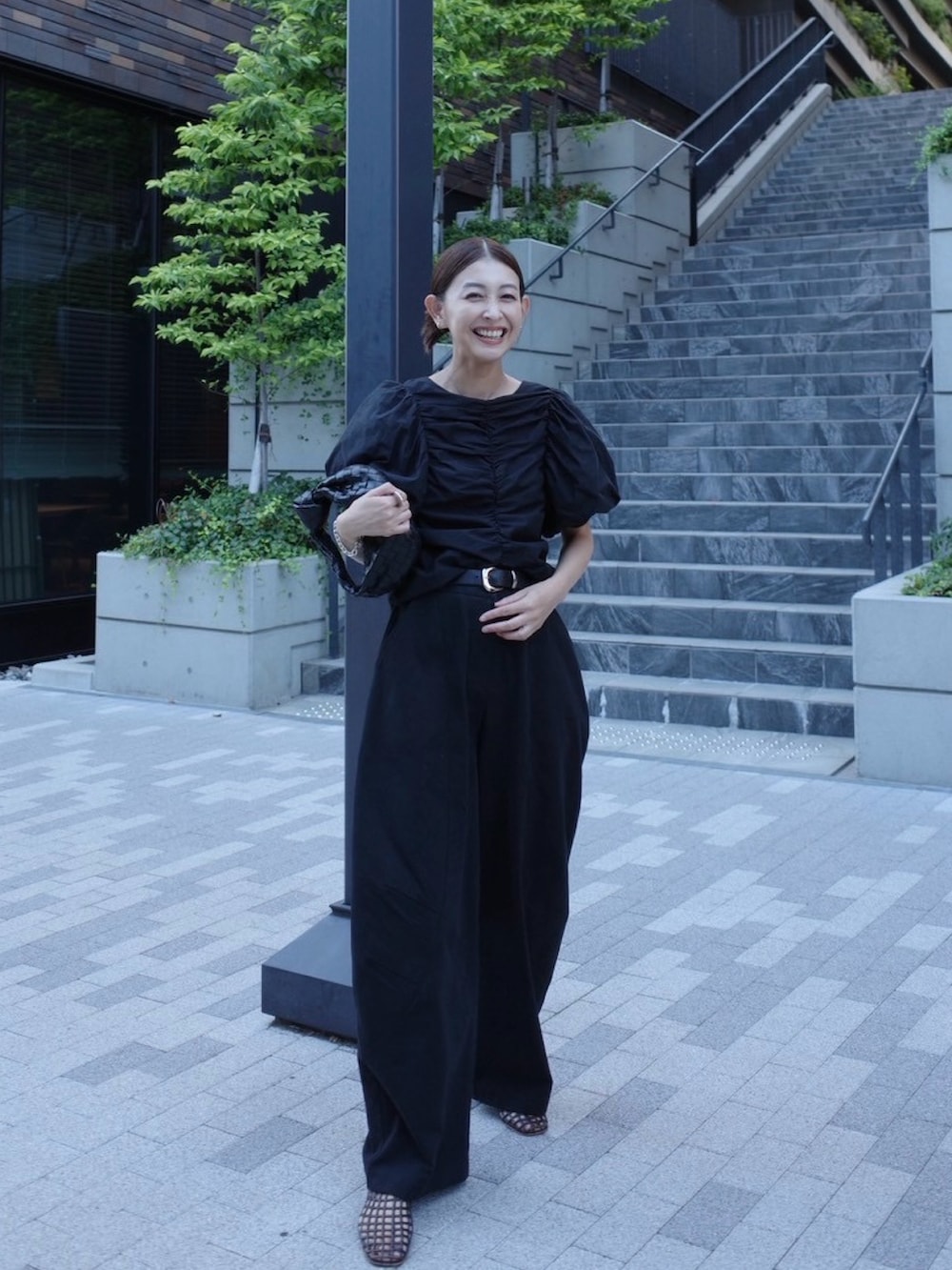 ブラック系のシャツ/ブラウス、ブラック系のチノパンツ、ブラウン系のバレエシューズを着用したレディースの秋コーディネートの4枚目の写真