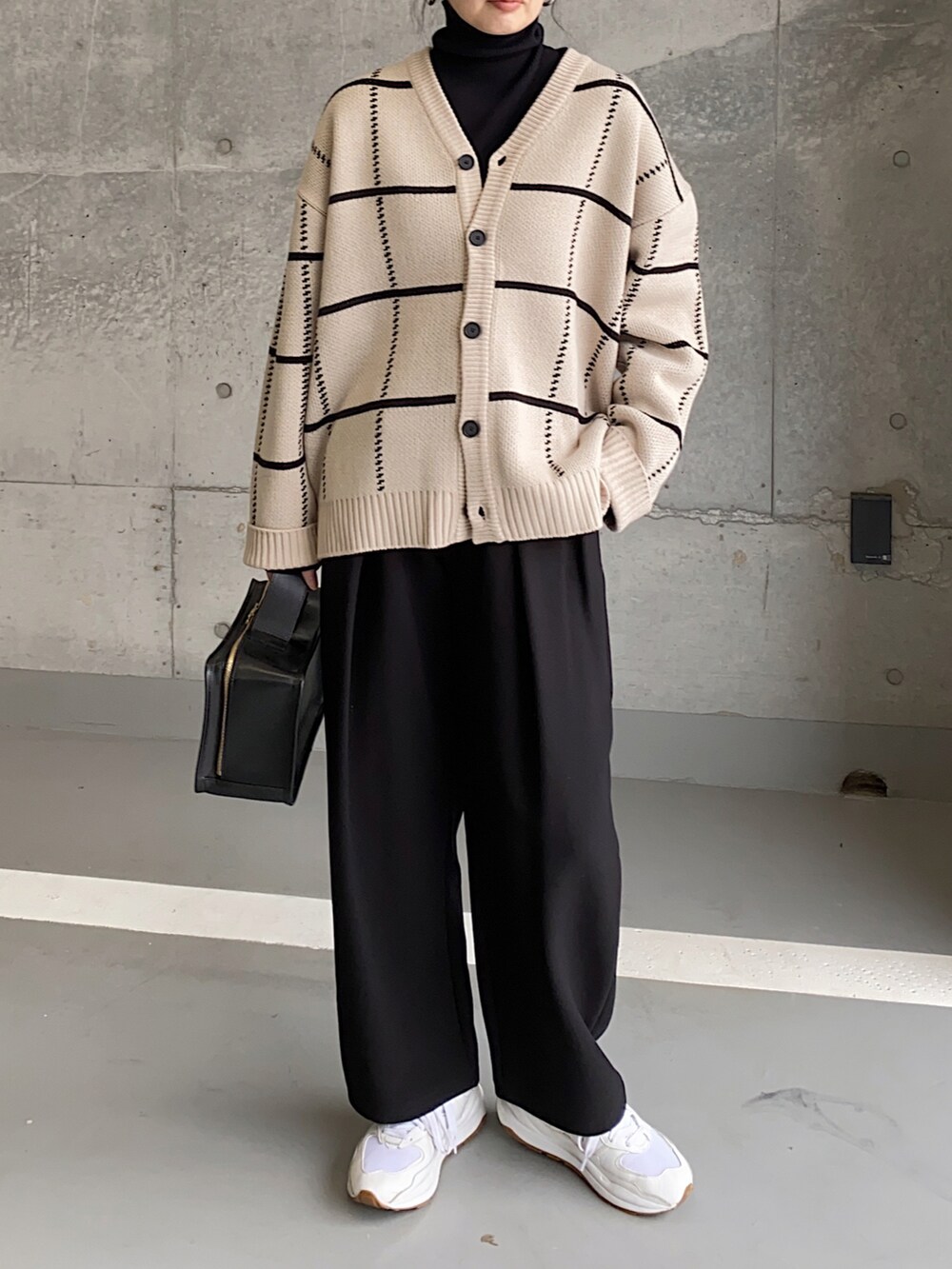 ベージュ系のカーディガン/ボレロ、ホワイト系のスニーカー、ブラック系のハンドバッグを着用したレディースの冬コーディネートの2枚目の写真