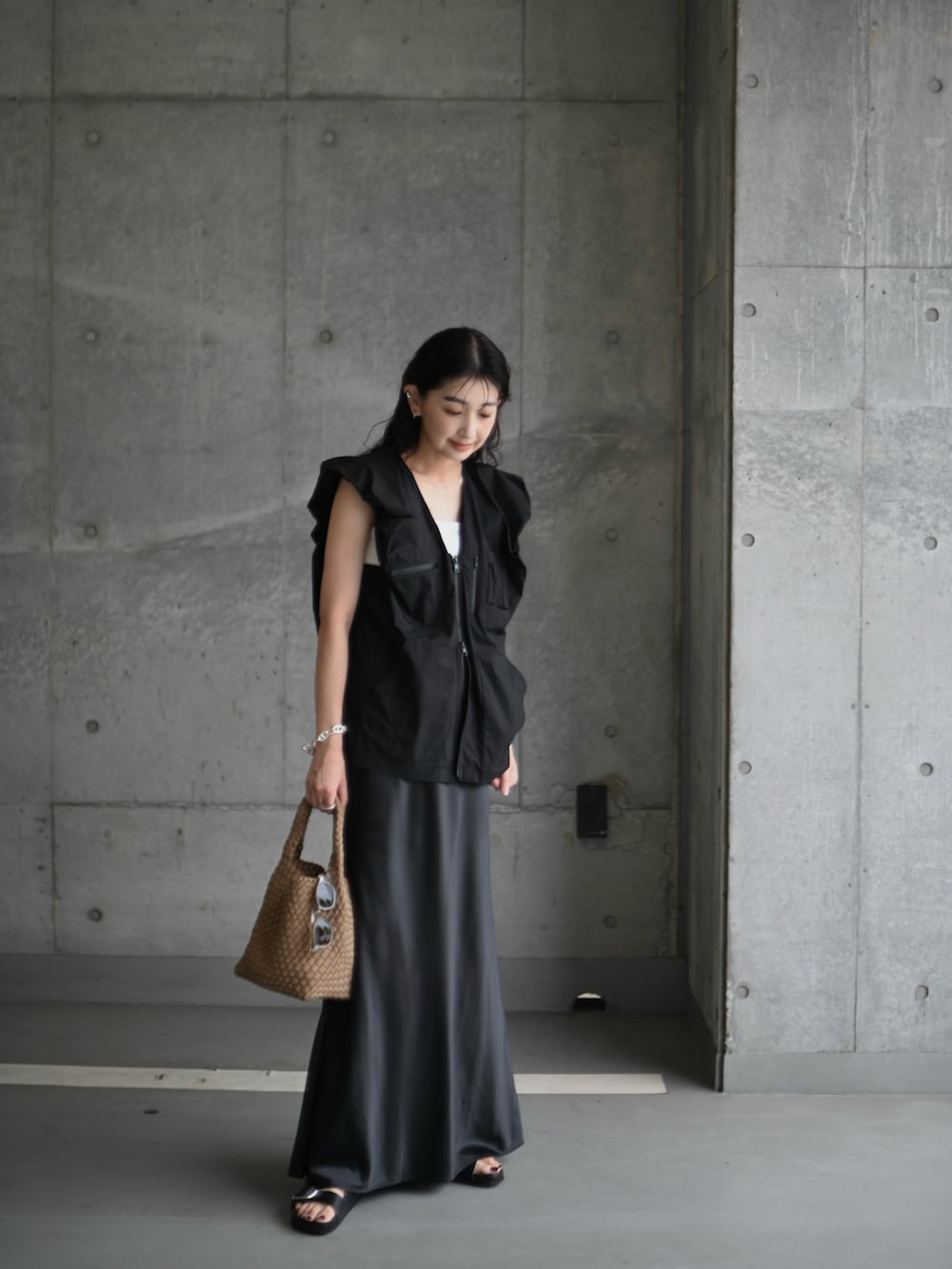 ブラック系のベスト、ブラック系のサンダル、ブラック系のスカートを着用したレディースの夏コーディネートの5枚目の写真