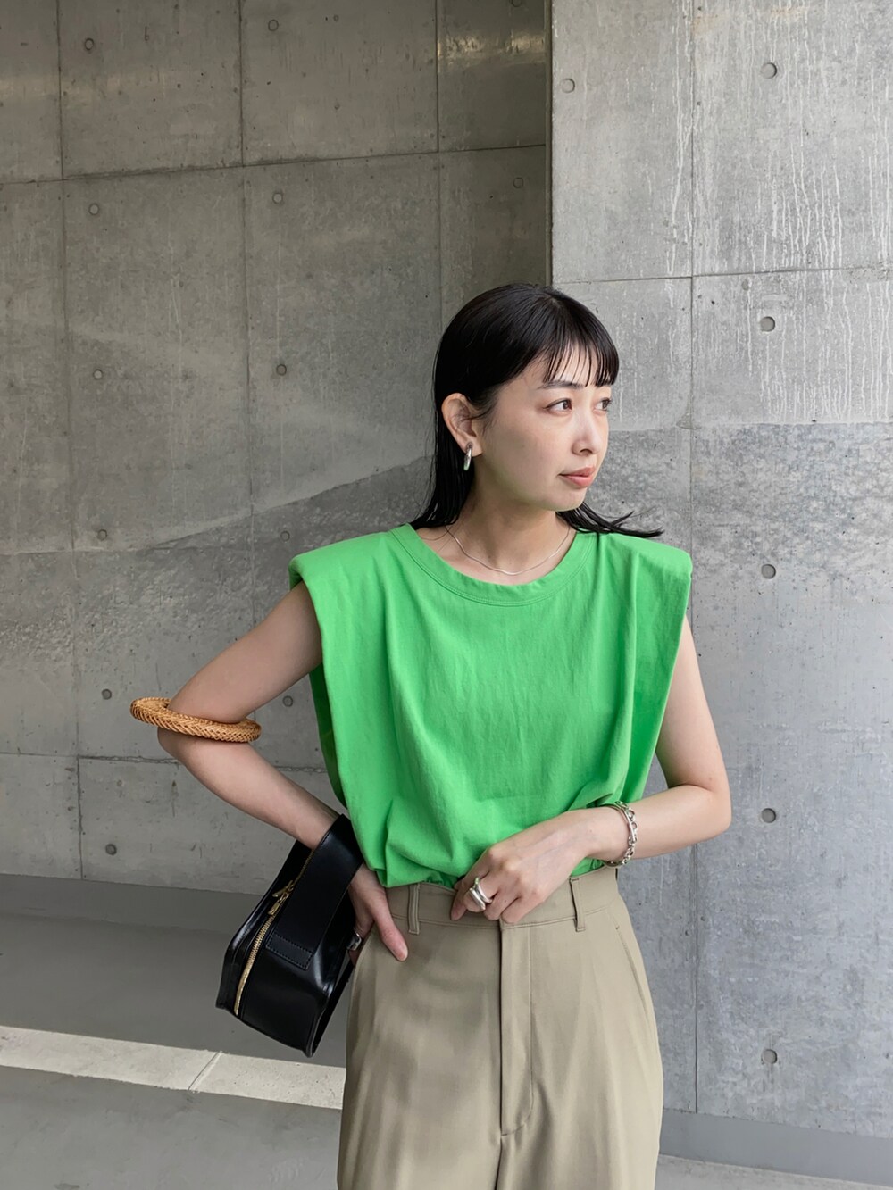 グリーン系のTシャツ/カットソー、ベージュ系のその他パンツ、ブラック系のハンドバッグを着用したレディースの夏コーディネートの3枚目の写真