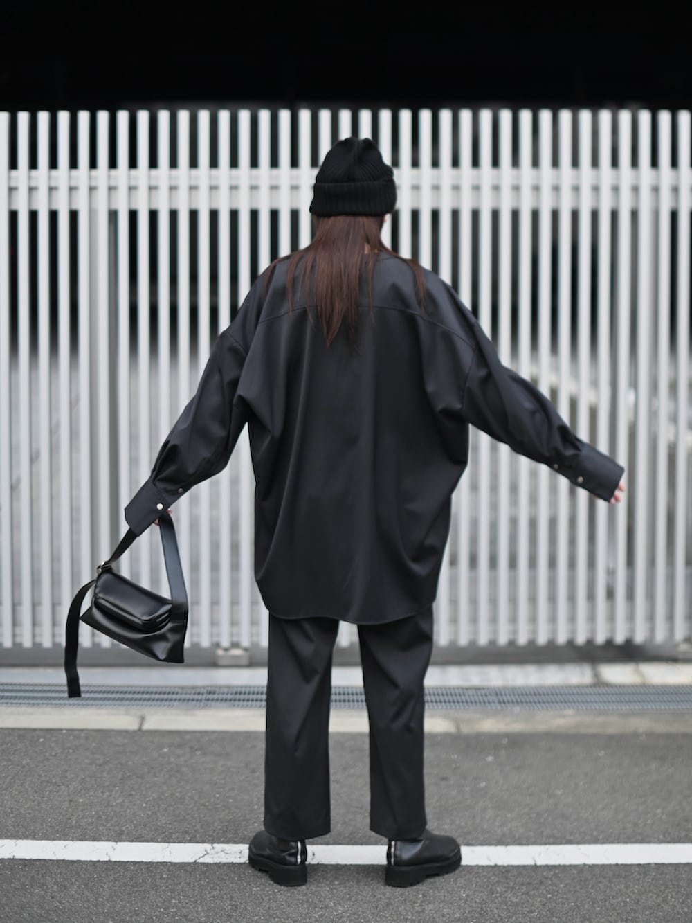 グレー系のシャツ/ブラウス、グレー系のスラックス、ブラック系のショルダーバッグを着用したレディースの冬コーディネートの3枚目の写真