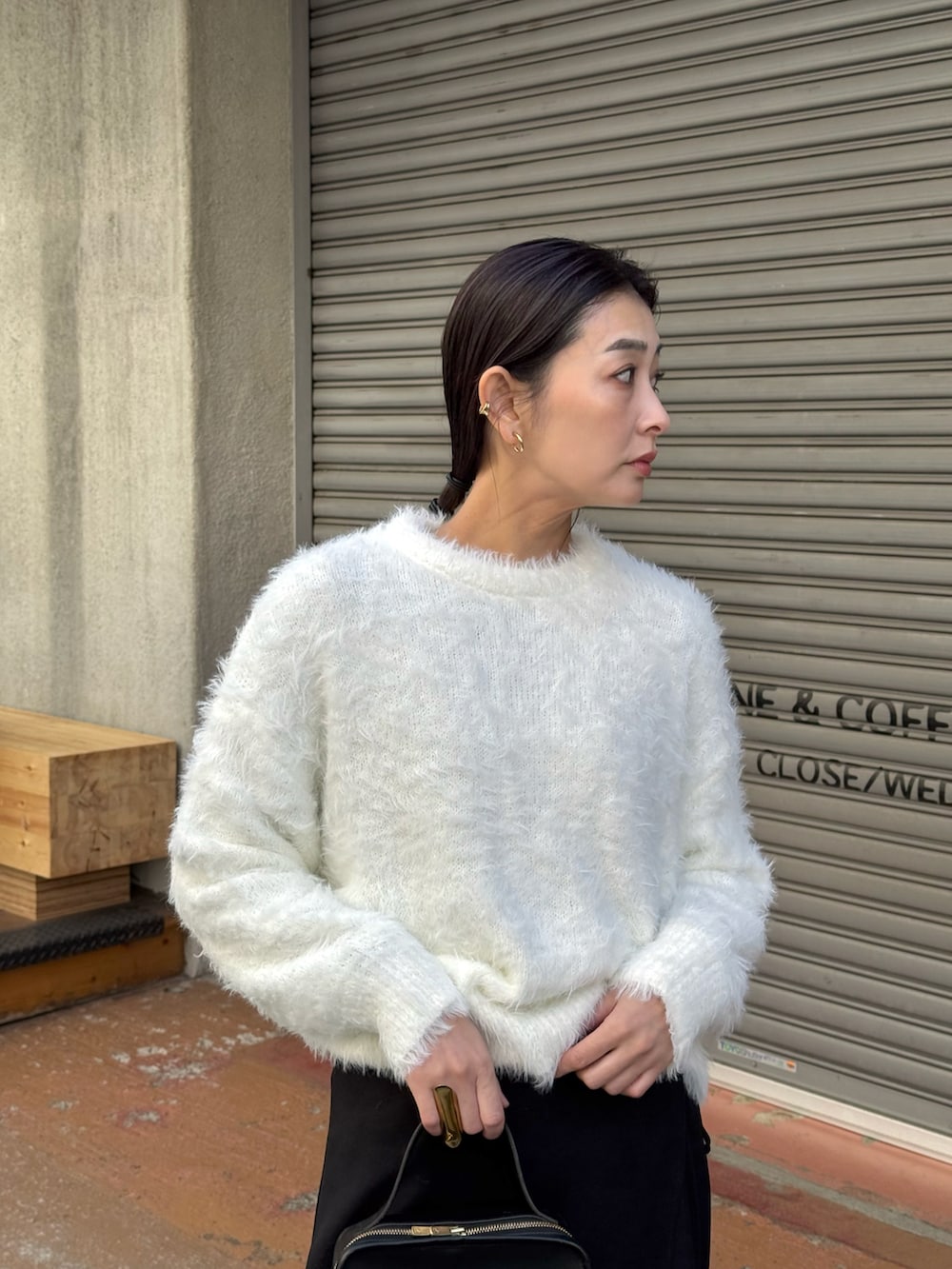 ホワイト系のニット/セーター、ブラック系のスラックス、ブラック系のローファーを着用したレディースの冬コーディネートの3枚目の写真