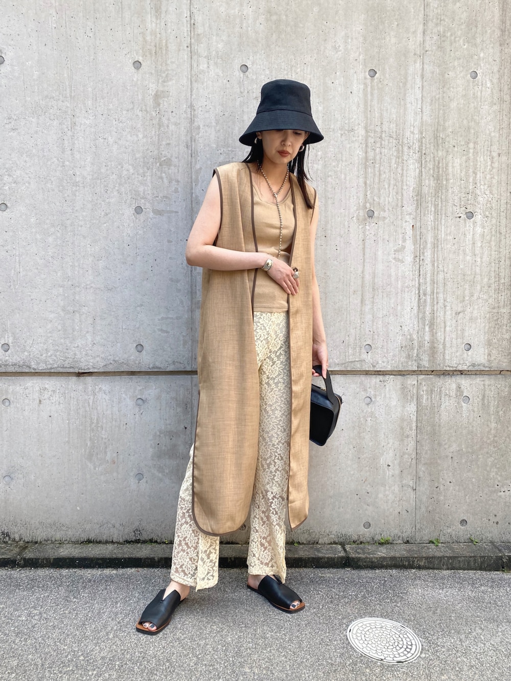 ホワイト系のその他パンツ、ブラック系のハット、シルバー系のネックレスを着用したレディースの夏コーディネートの2枚目の写真