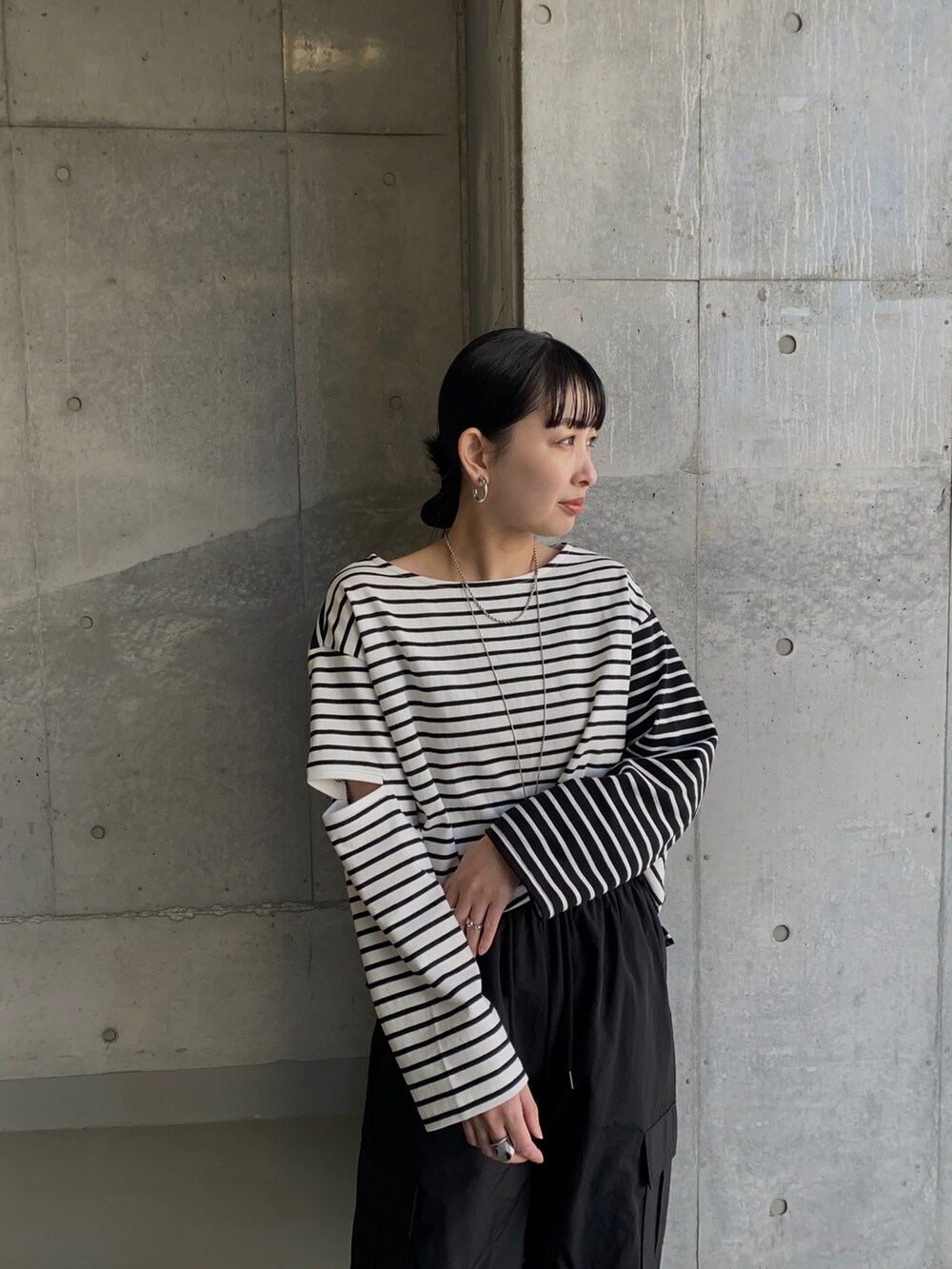 ブラック系のTシャツ/カットソー、ブラック系のその他パンツ、イエロー系のハンドバッグを着用したレディースの春コーディネートの2枚目の写真