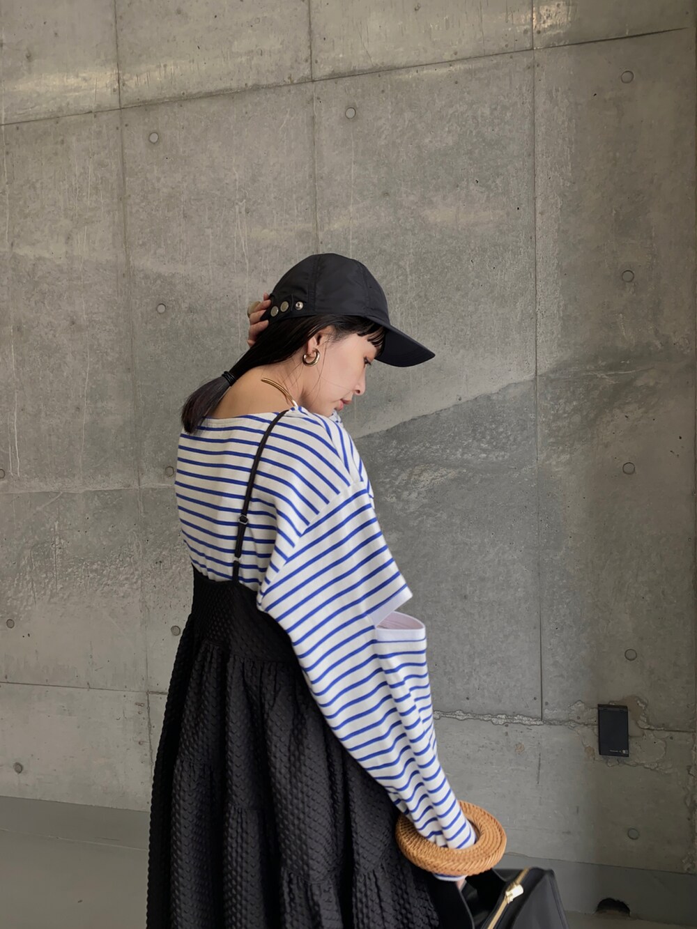 ブルー系のTシャツ/カットソー、ブラック系のワンピース、ゴールド系のネックレスを着用したレディースの春コーディネートの3枚目の写真