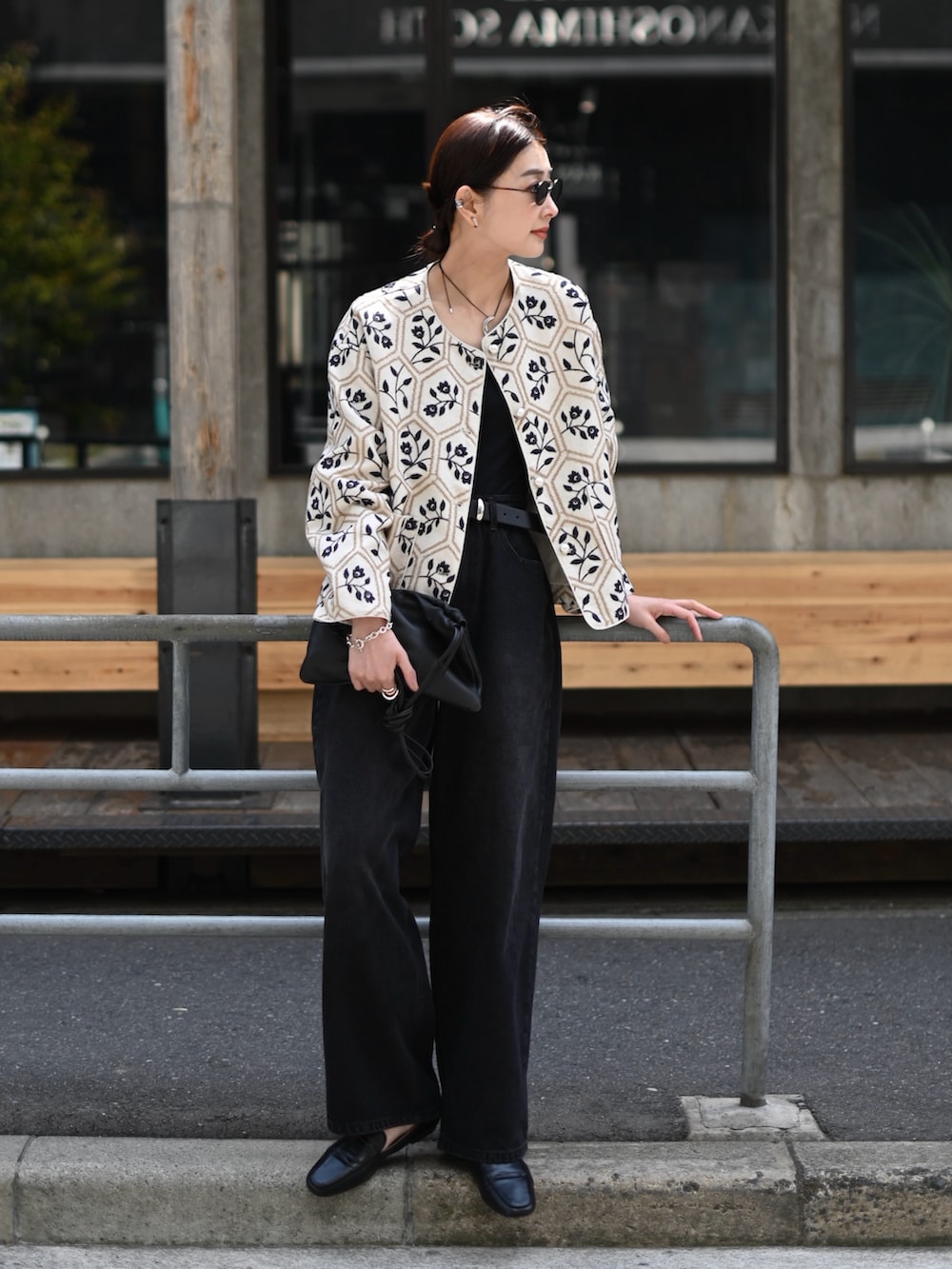 ブラック系のデニムパンツ、ブラック系のチューブトップ、ベージュ系のノーカラージャケットを着用したレディースの春コーディネートの2枚目の写真