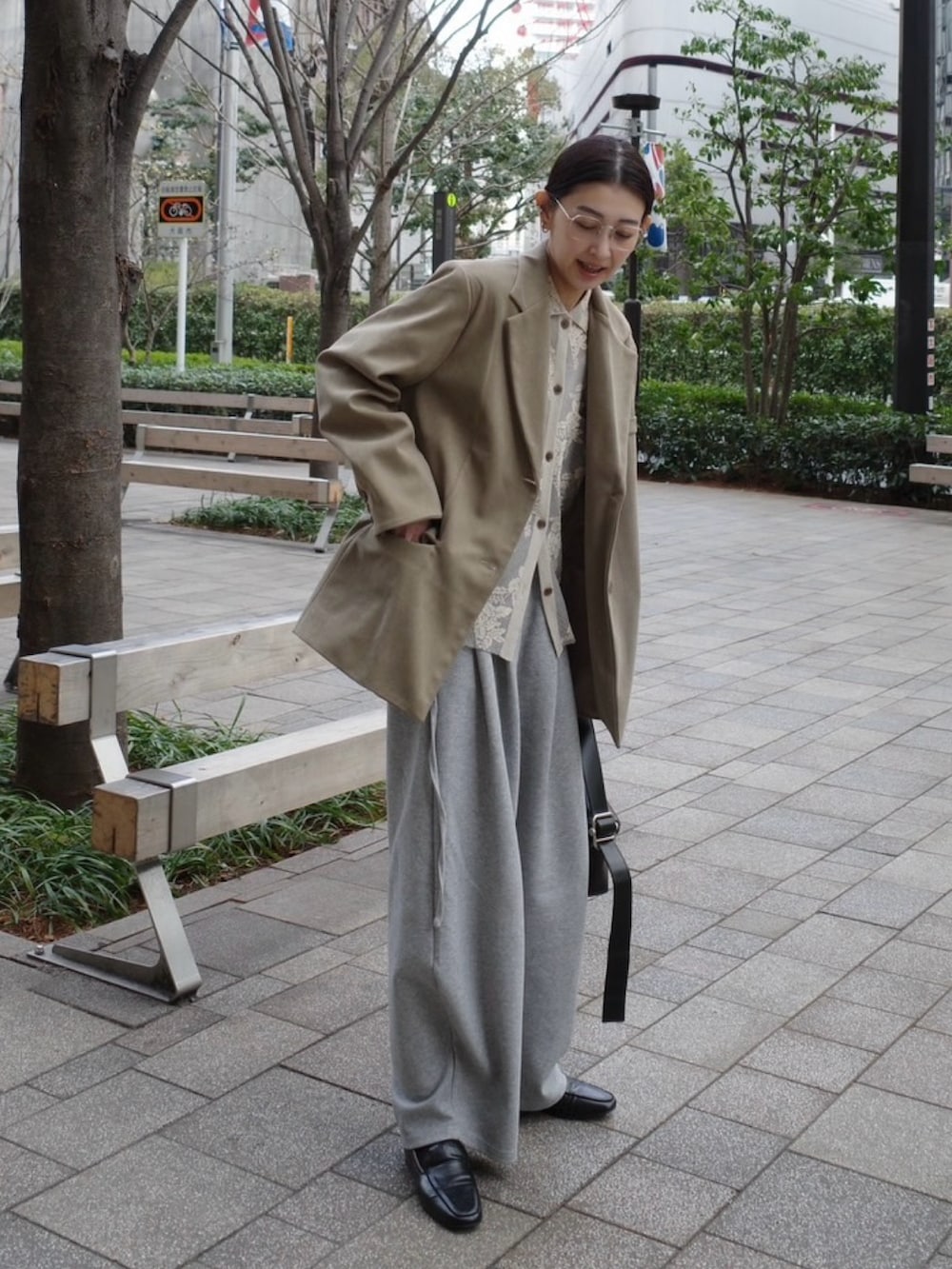 ベージュ系のテーラードジャケット、ブラック系のショルダーバッグ、グレー系のスウェットパンツを着用したレディースの春コーディネートの5枚目の写真