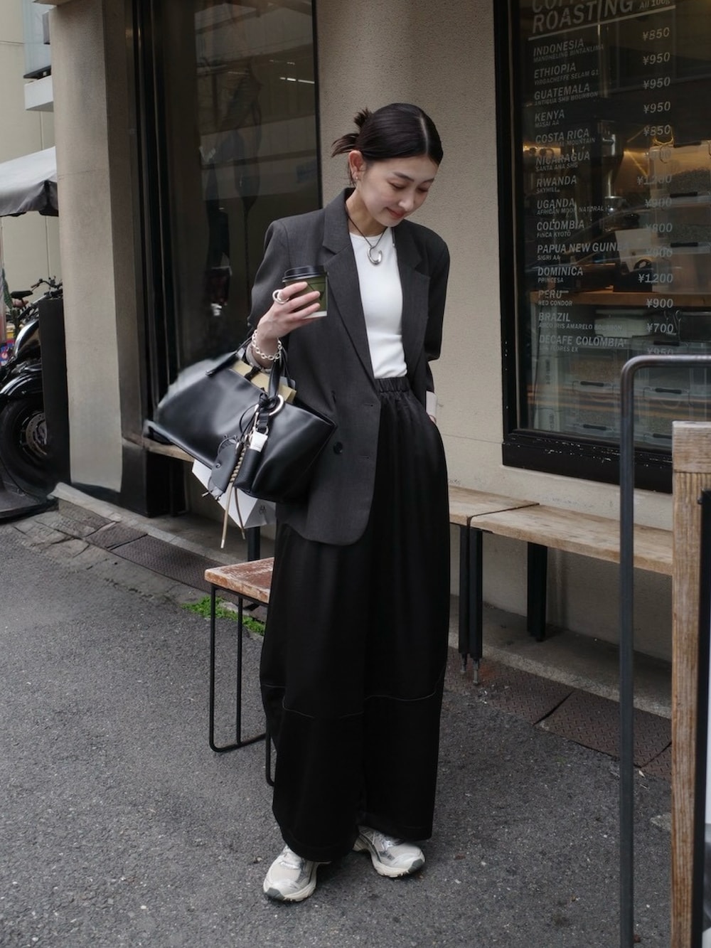 ブラック系のその他パンツ、グレー系のテーラードジャケット、ベージュ系のその他小物を着用したレディースの春コーディネートの5枚目の写真