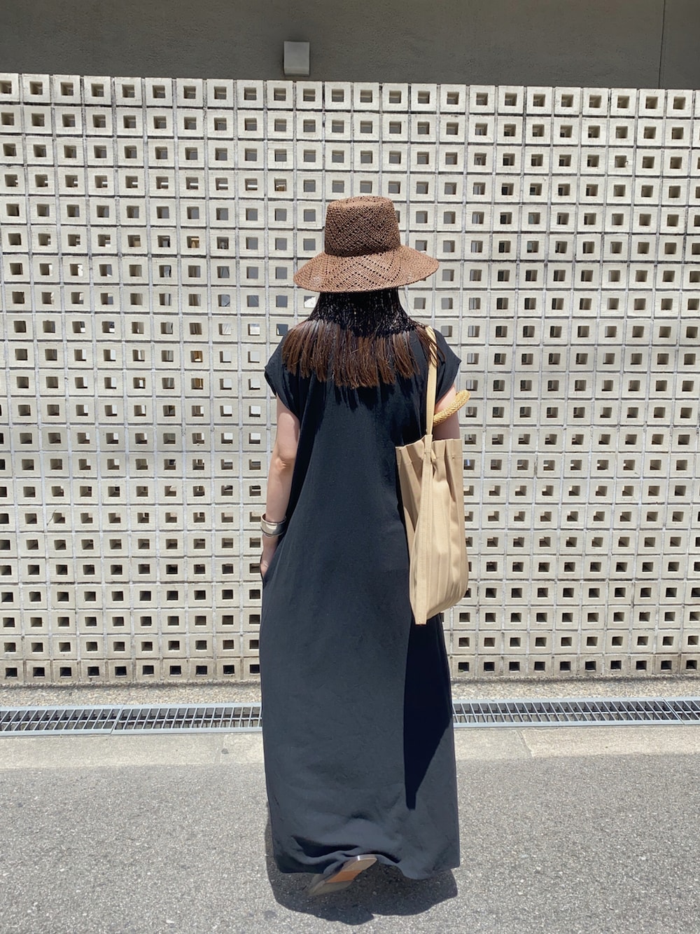 ブラック系のワンピース、ブラウン系のハット、シルバー系のネックレスを着用したレディースの夏コーディネートの3枚目の写真