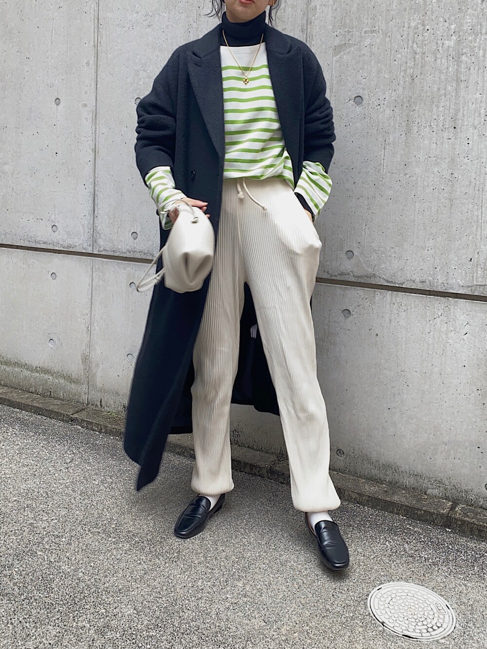 グリーン系のTシャツ/カットソー、ホワイト系のその他パンツ、ブラック系のローファーを着用したレディースの冬コーディネートの3枚目の写真