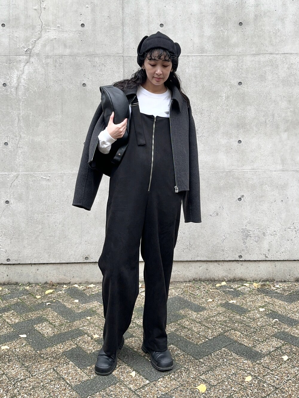 グレー系のブルゾン、ブラック系のサロペット/オーバーオール、ホワイト系のTシャツ/カットソーを着用したレディースの冬コーディネートの3枚目の写真