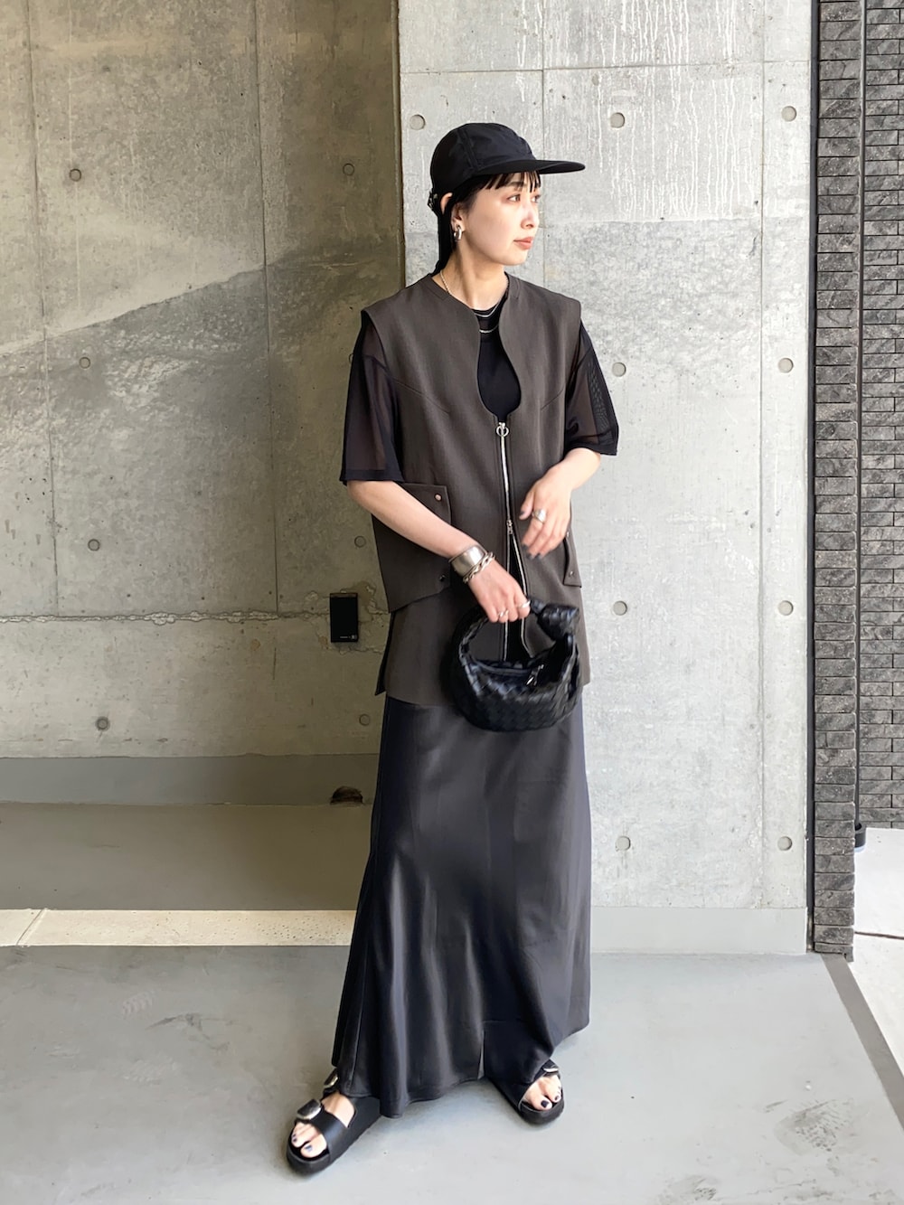 ブラック系のTシャツ/カットソー、グレー系のベスト、ブラック系のサンダルを着用したレディースの夏コーディネートの3枚目の写真