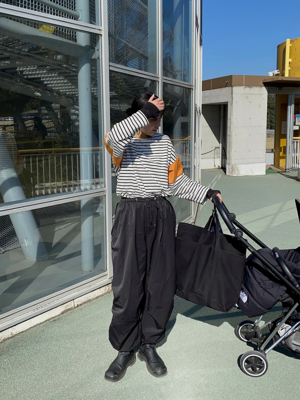 ブラック系のその他パンツ、ブラック系のTシャツ/カットソー、ブラック系のトートバッグを着用したレディースの春コーディネートの2枚目の写真