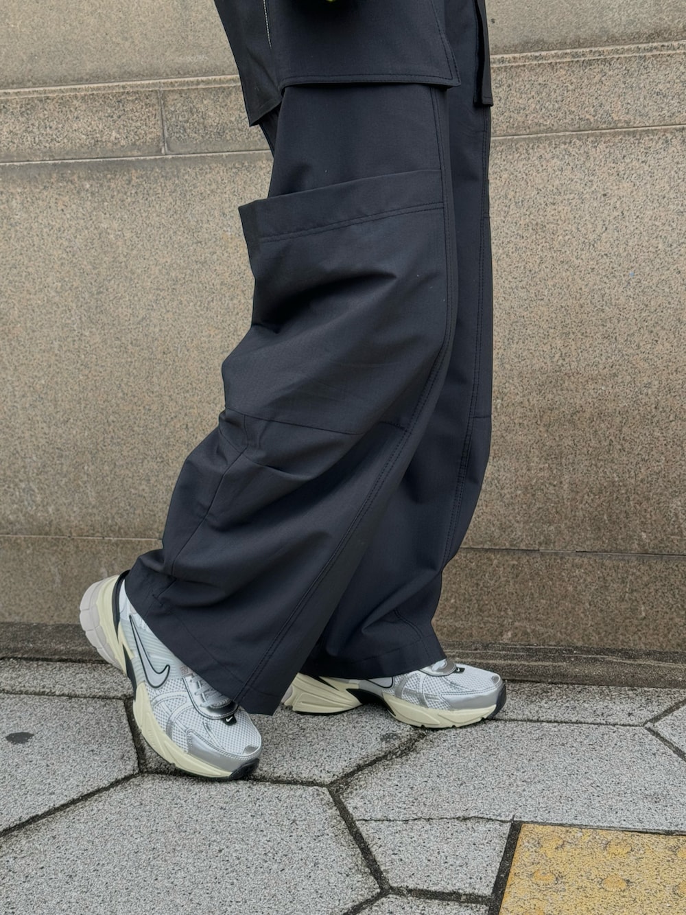 グレー系のブルゾン、ブラック系のショルダーバッグ、グリーン系のカーゴパンツを着用したレディースの冬コーディネートの4枚目の写真