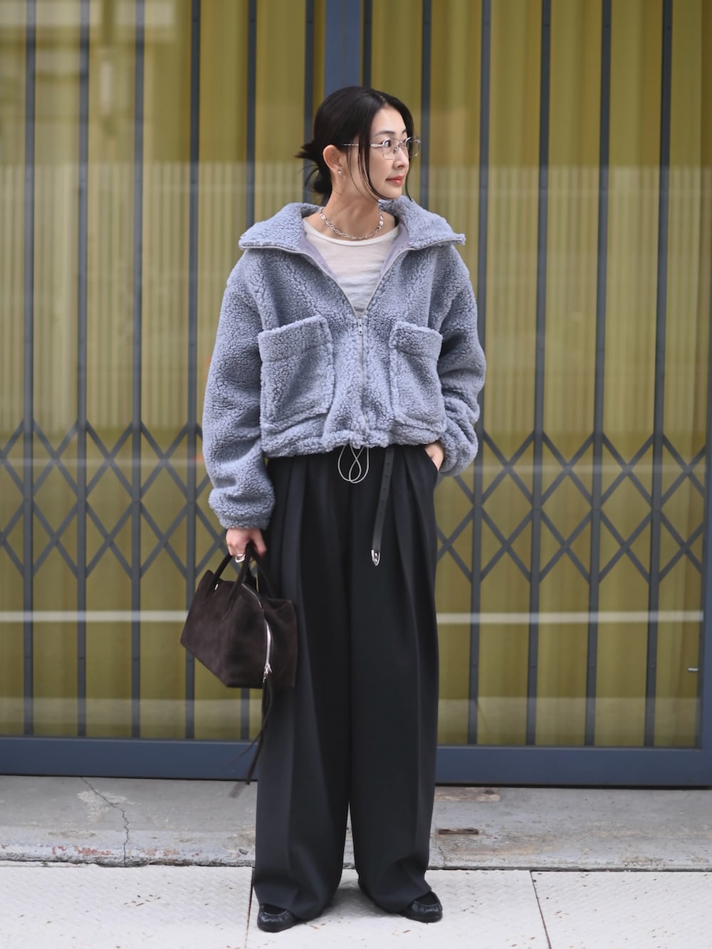 グレー系のその他アウター、グレー系のその他パンツ、ブラウン系のボストンバッグを着用したレディースの冬コーディネートの2枚目の写真