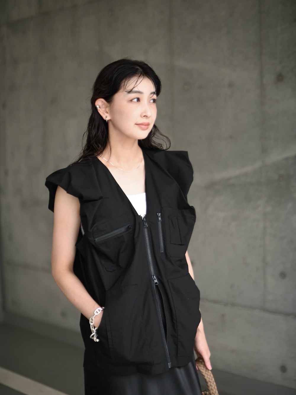 ブラック系のベスト、ブラック系のサンダル、ブラック系のスカートを着用したレディースの夏コーディネートの3枚目の写真