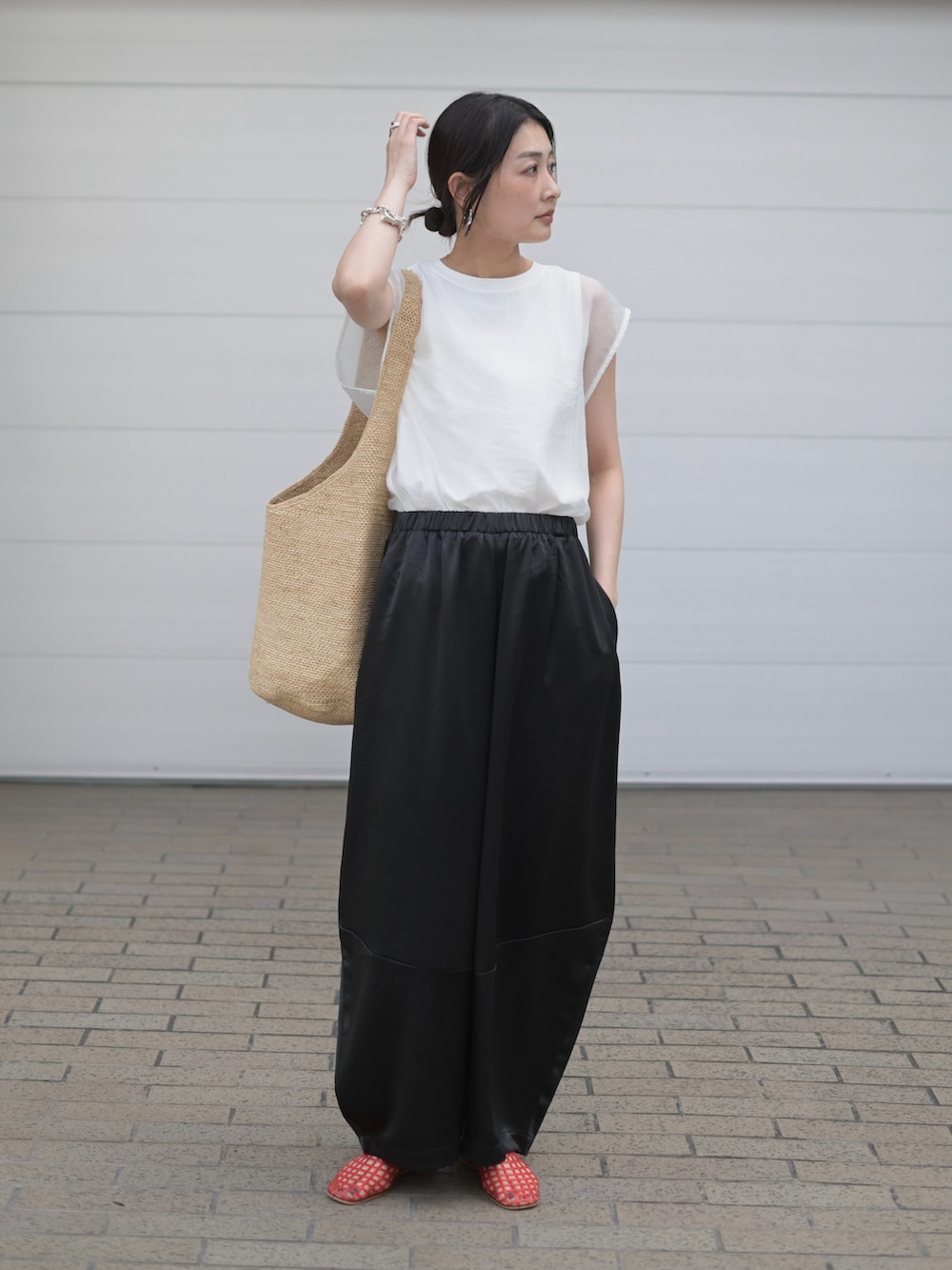 ブラック系のその他パンツ、ホワイト系のTシャツ/カットソー、ベージュ系のかごバッグを着用したレディースの夏コーディネートの4枚目の写真